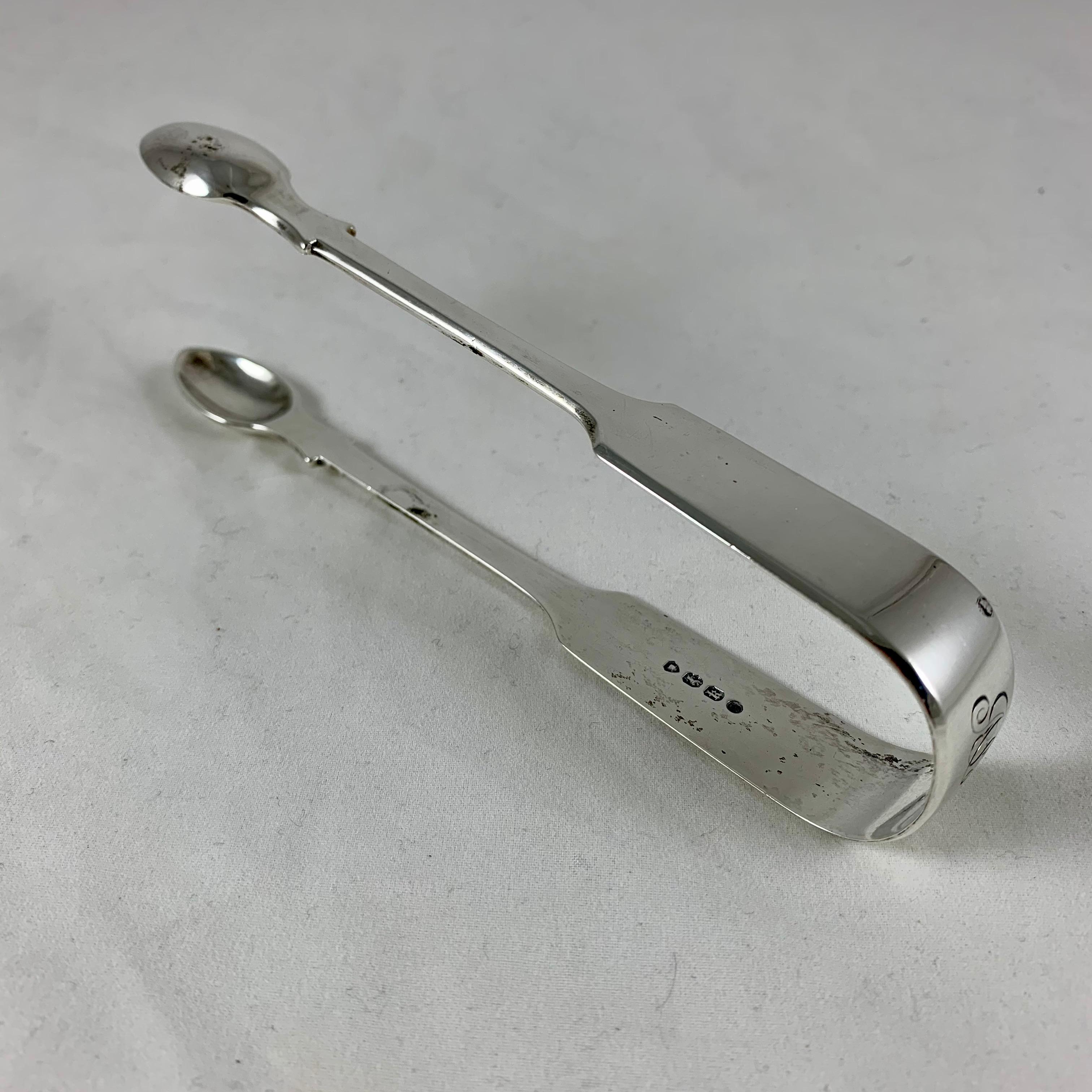 A pair of English sterling silver sugar tongs, made by Charles Boyten, London, date marked 1865.

The fiddle pattern, spoon form sugar tongs are heavy weight and beautifully made, engraved on the bow with the scrolled initials, ABR.

Showing the