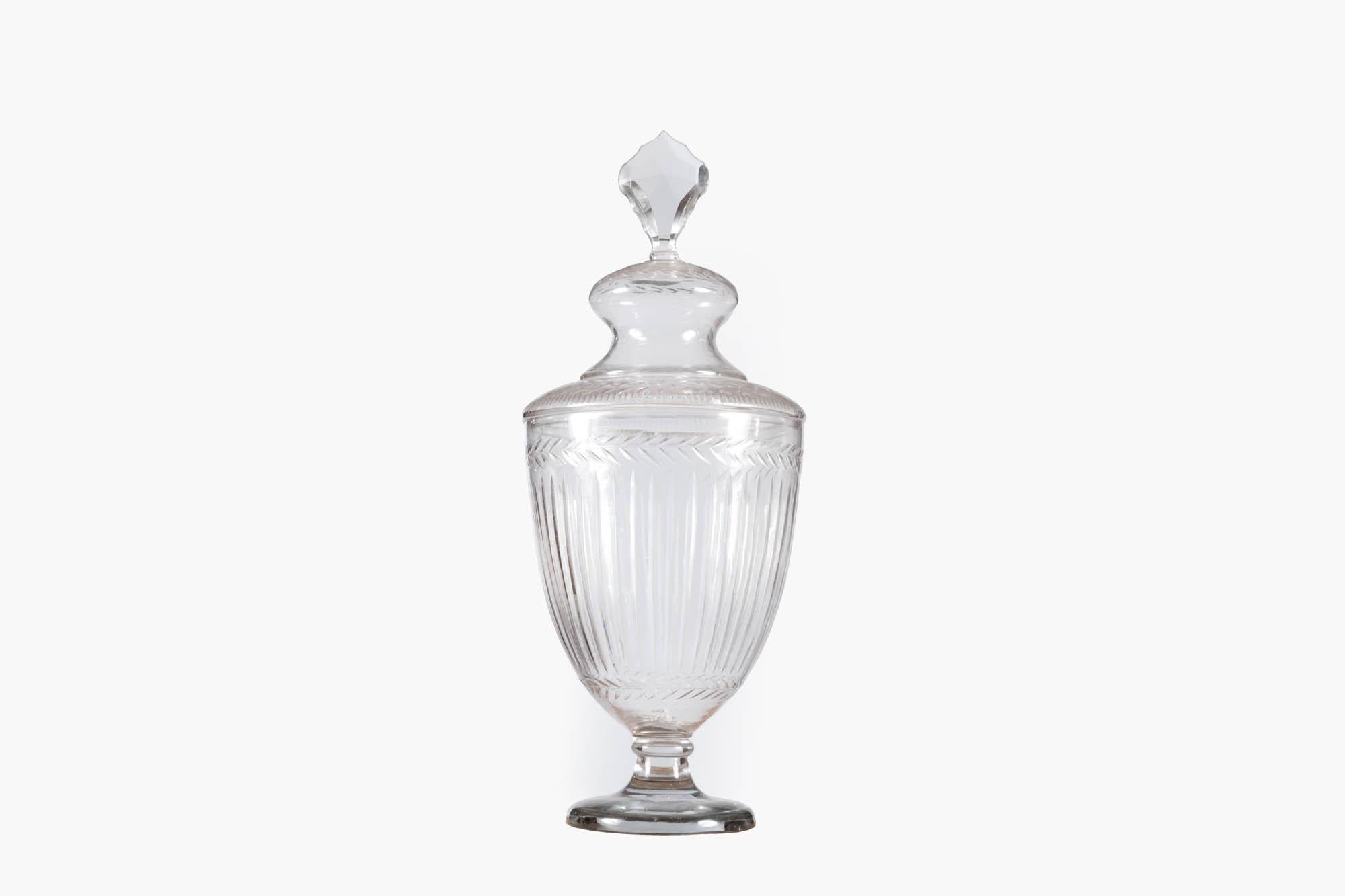 19th Century Irish etched glass bonboniere or fruit-cooler jar. Raised on a rounded stemmed base with a goblet-style body featuring vertical cutting and a horizontal band of cut ‘laurel-leaf’ decoration. The removable dome-top is complete with