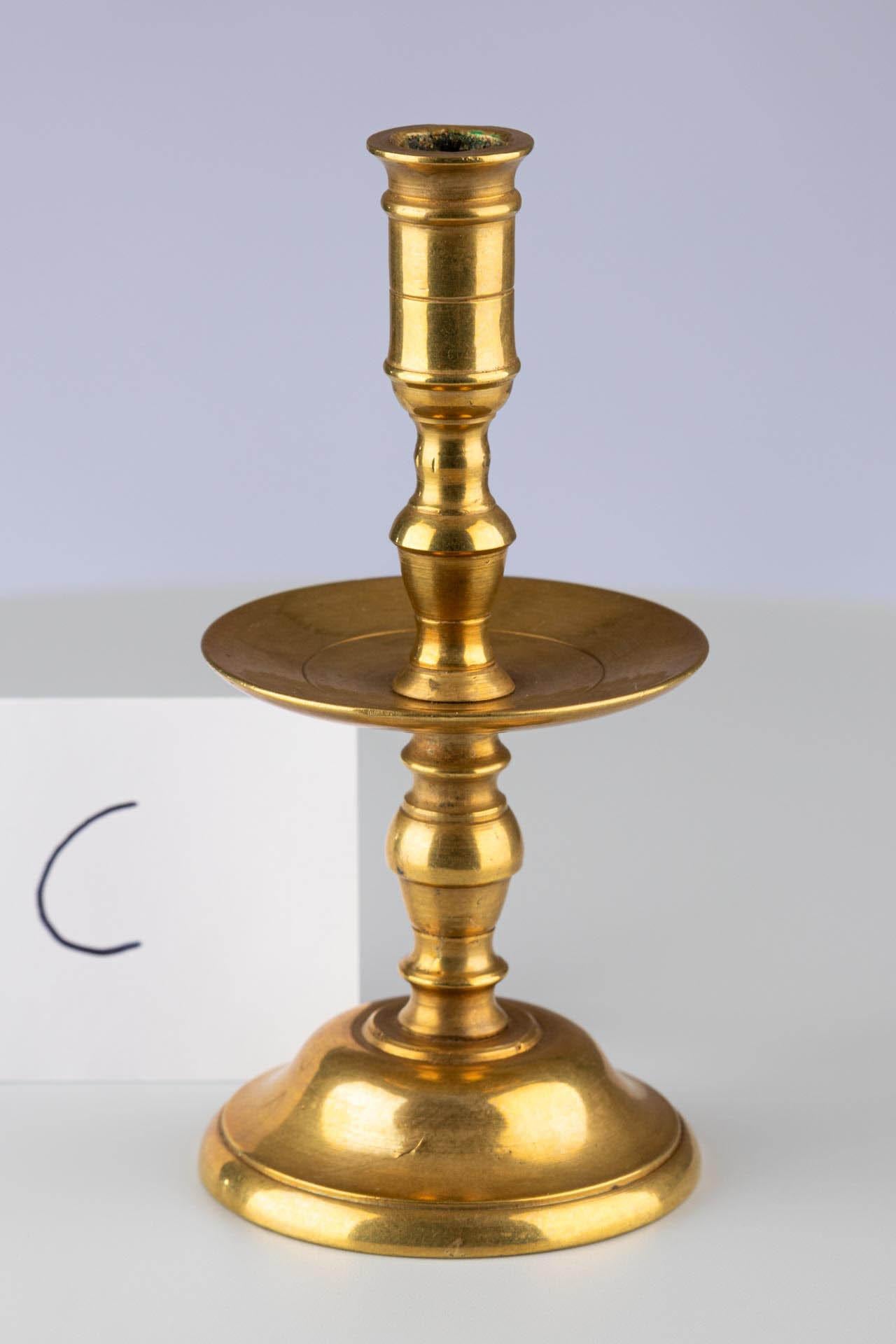 Kerzenleuchter aus gedrehtem Messing mit Tropfschale

Herkunft: Wahrscheinlich Mitteleuropa
MATERIAL: Messing, gedreht und montiert
Datum: Frühes 19. Jahrhundert (ca. 1800-1820)

Beschreibung:
Ein einflammiger Kerzenleuchter aus gedrehtem Messing,