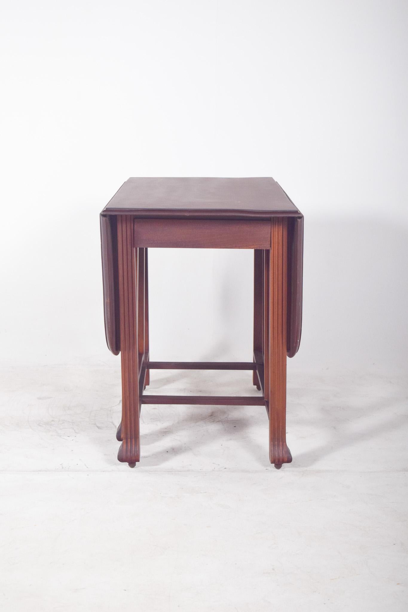 Table en forme de feuille avec un plateau ovale. Les pieds élégamment incurvés soutiennent la structure. Le plateau central est fixe, tandis que les panneaux latéraux peuvent être relevés ou abaissés selon les besoins, offrant ainsi une grande