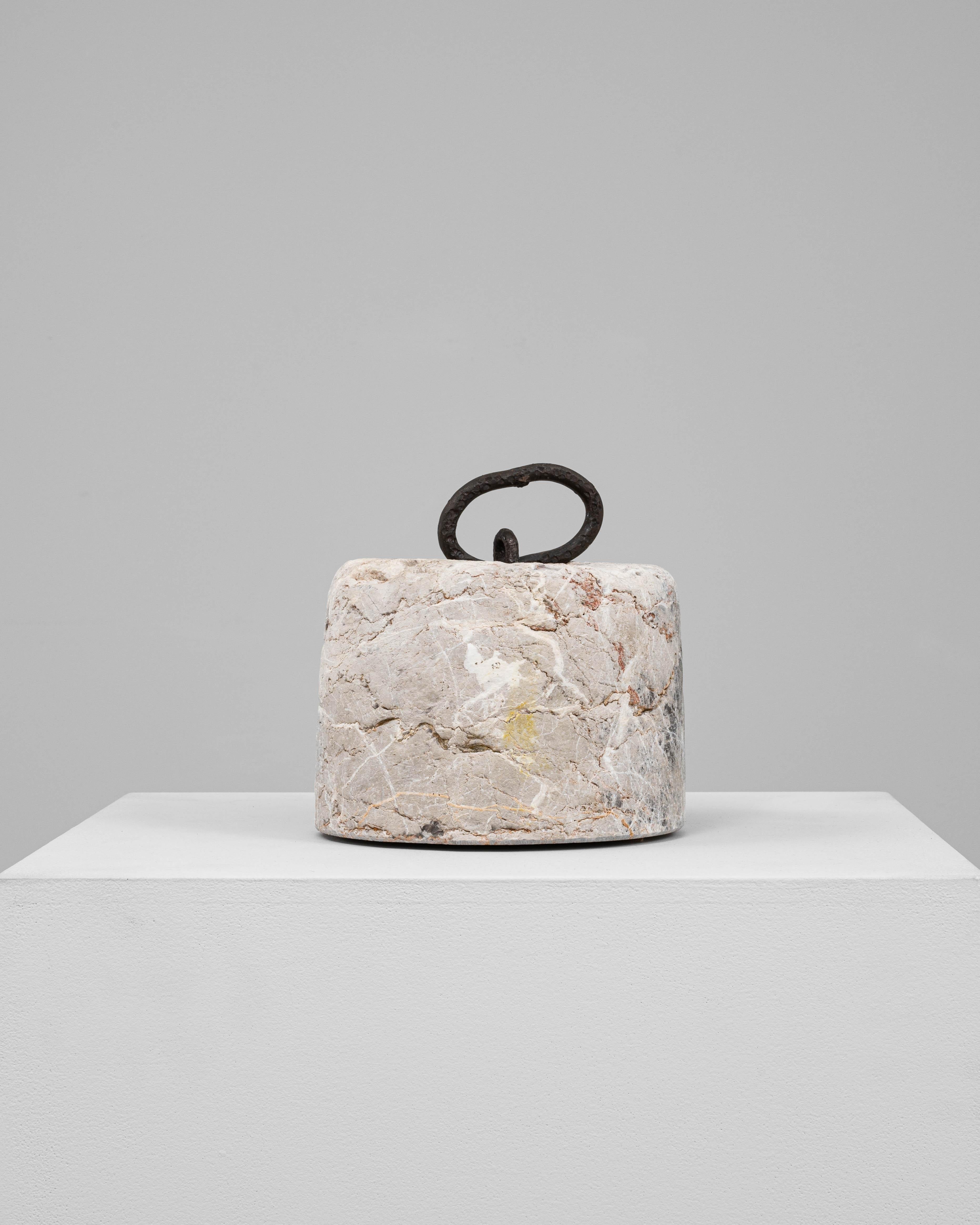 This 19th Century European marble door stop is a utilitarian object imbued with timeless materiality and charm. Hand-carved from solid marble, its cylindrical form features natural veining in tones of gray, ochre, and rust, with surface wear and