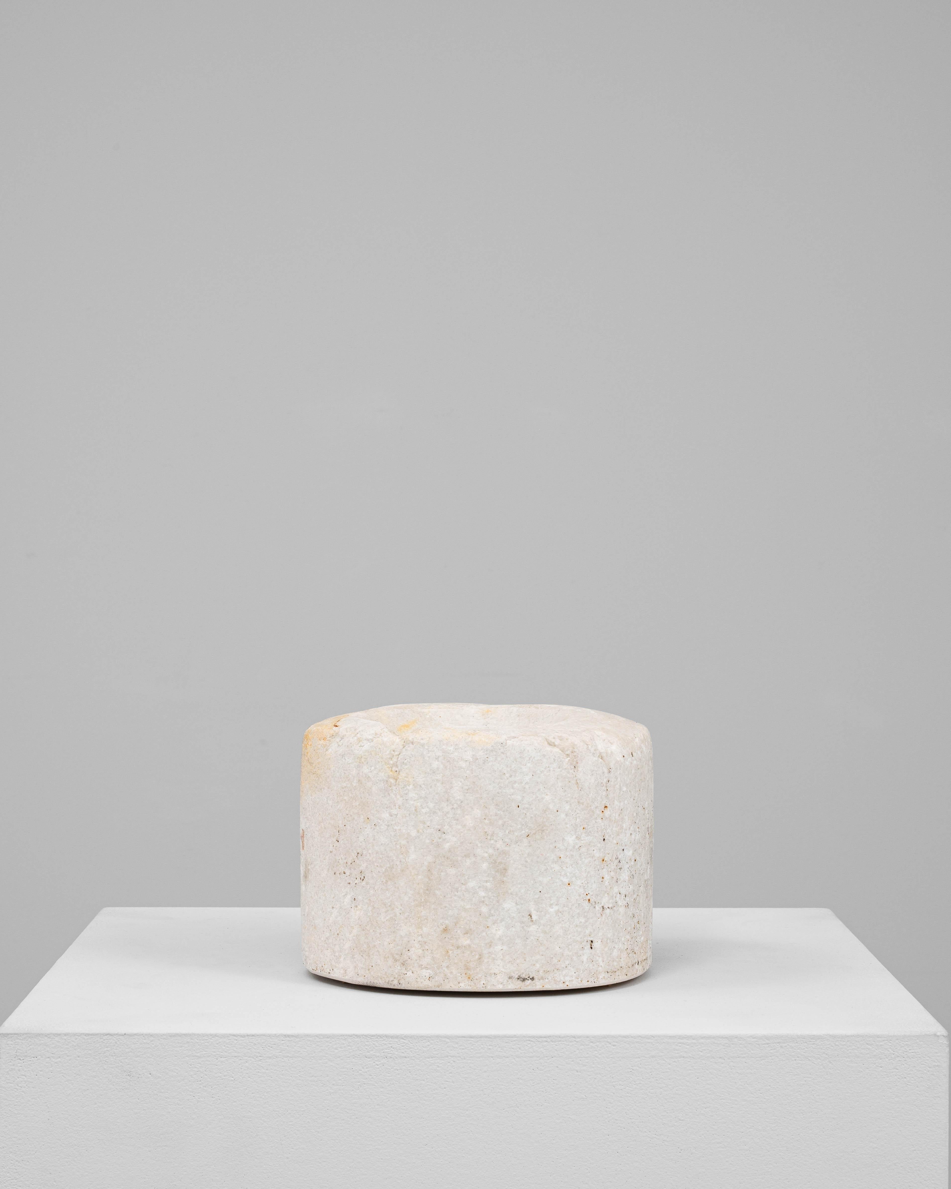 This 19th Century European marble mortar is a refined utilitarian object, hand-carved from pale stone with a smooth, cylindrical form and gently concave center. The creamy white marble features subtle veining and warm mineral tones that add depth