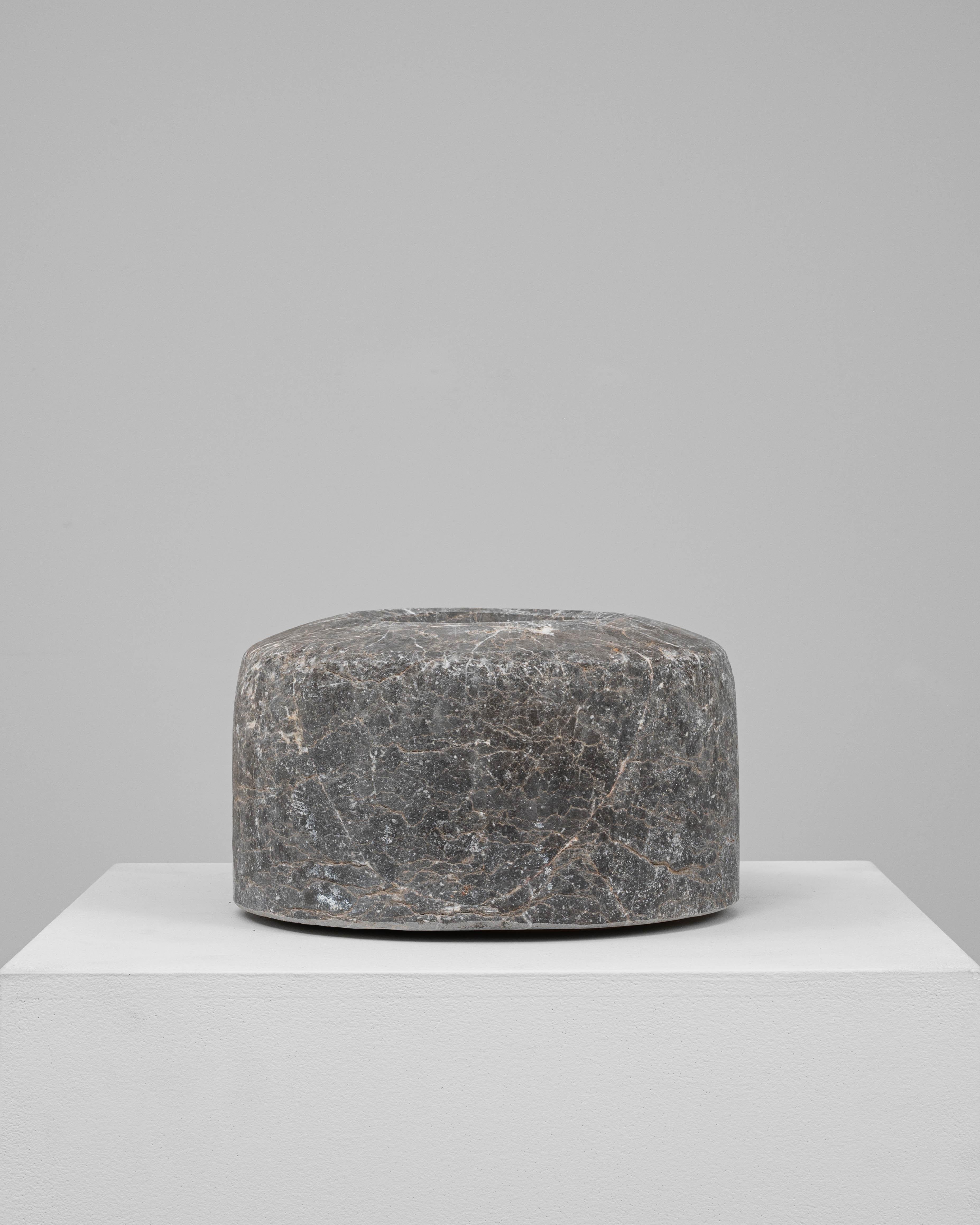 This 19th Century European marble mortar is a striking piece, hand-carved from richly veined dark gray marble with intricate white and ochre veining throughout. The cylindrical form is clean and substantial, with a softly recessed center worn smooth
