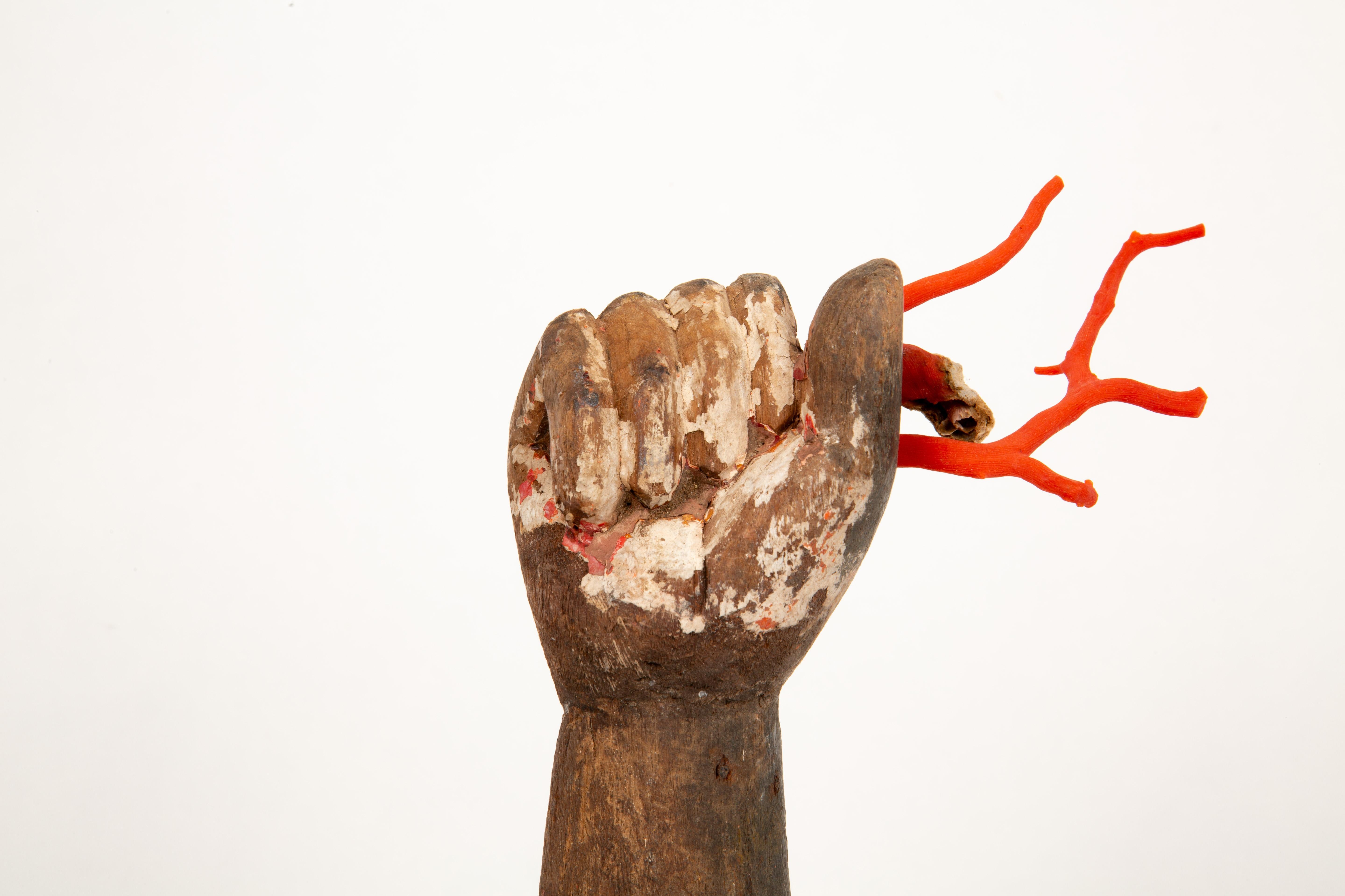 A striking and evocative piece, this custom-mounted Santos hand hails from 19th-century Europe, showcasing the unique craftsmanship of religious art from the period. Carved from wood, the hand exhibits signs of wear and age, with remnants of