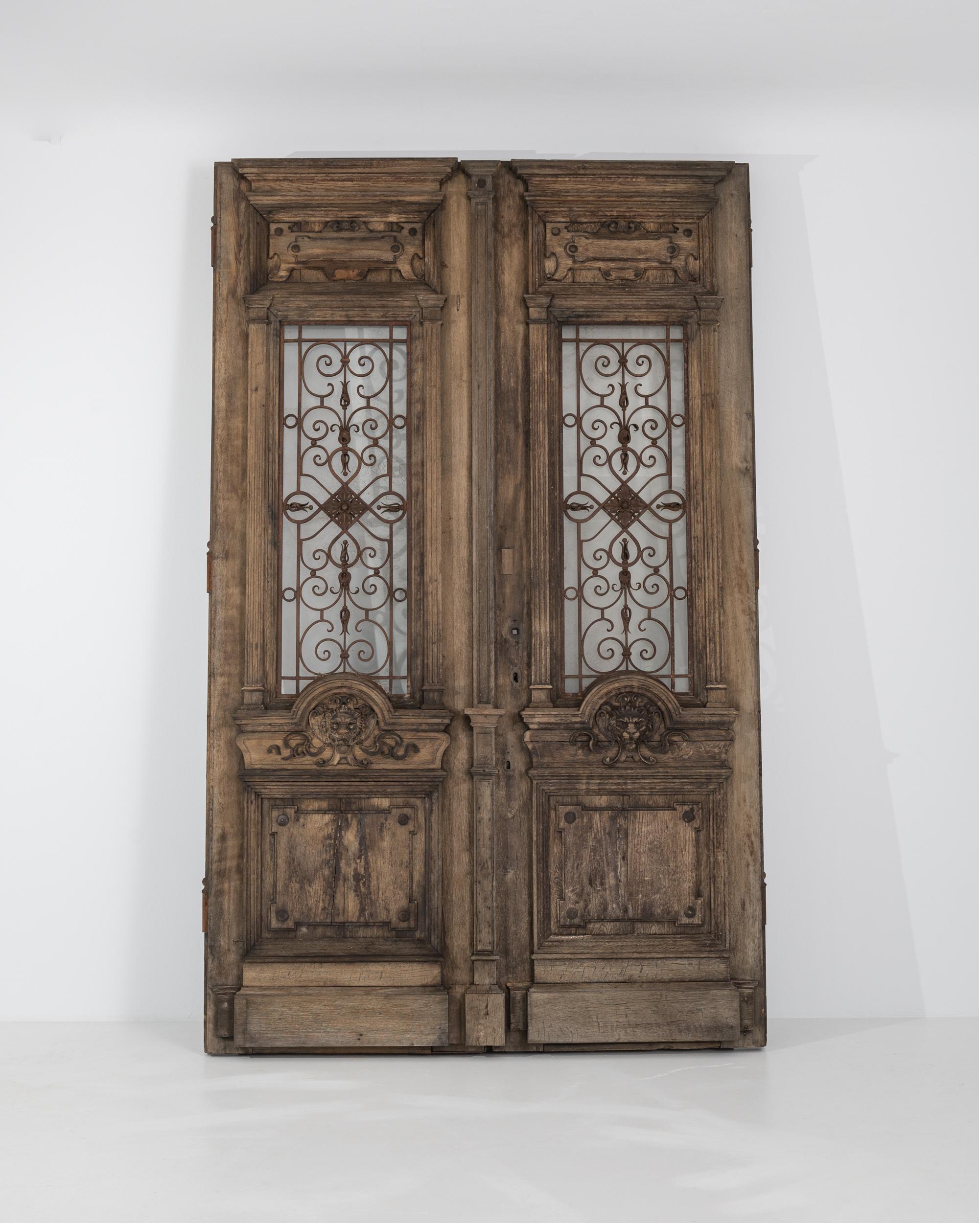 Mysterious and ornate, this magnificent pair of antique wooden doors were made to be marveled over. Built in Central Europe in the 1800s, the weathered patina of the wood creates an impression of faded grandeur, but the beautifully crafted