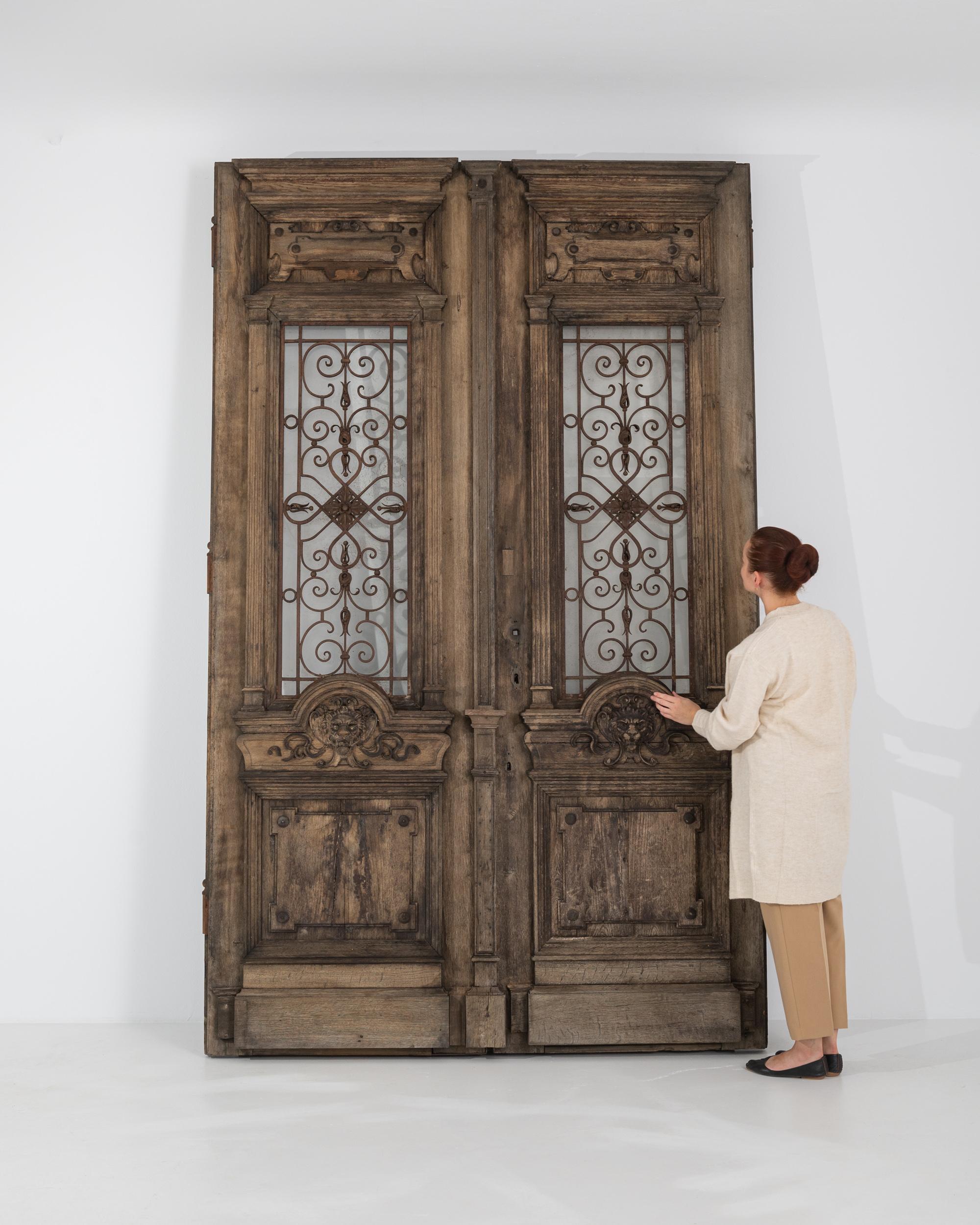 Mysterious and ornate, this magnificent pair of antique wooden doors were made to be marveled over. Built in Central Europe in the 1800s, the weathered patina of the wood creates an impression of faded grandeur, but the beautifully crafted