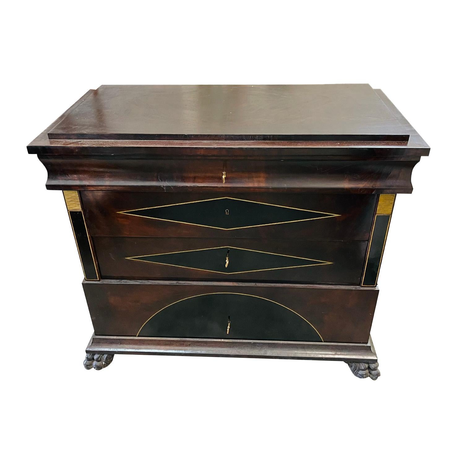 A late 19th Century, antique European commode made of hand crafted polished, partly veneered Mahogany in good condition. The commode is composed with four drawers, standing on two back wooden feet, supported on the front by two detailed carved lion