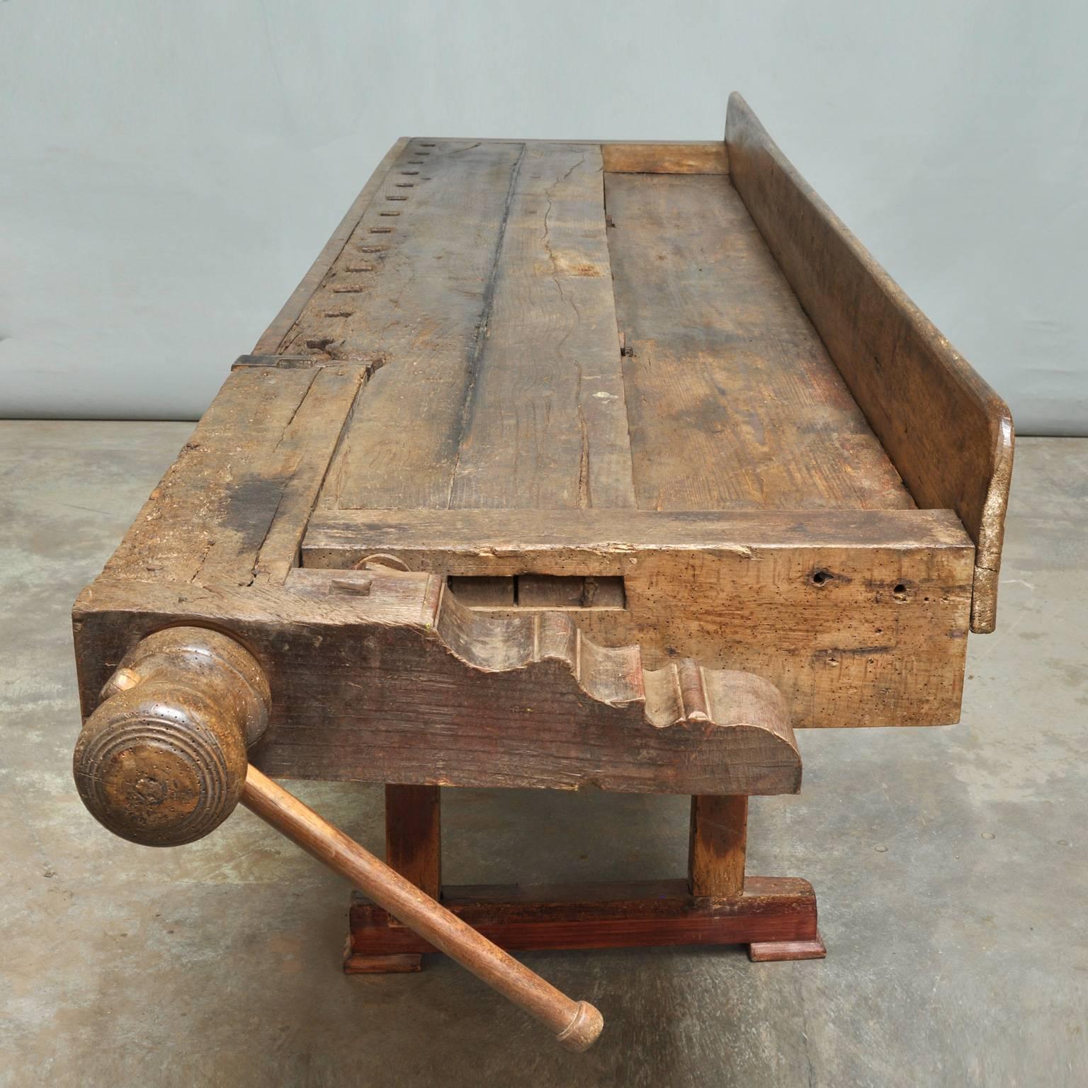 This antique Hungarian carpenter’s workbench features hand-carved built-in wooden vice and a recessed tray where the carpenter would lay his tools. It was manufactured in 1895 (signed by the maker at the bottom of the top).
 