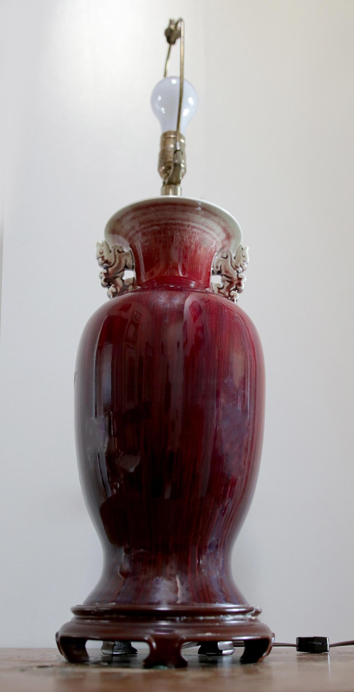The intricately carved handles, or ears of this oxblood lamp cause it to stand out from the field of other lamps of this type. This piece is a 19th century sang de boeuf 