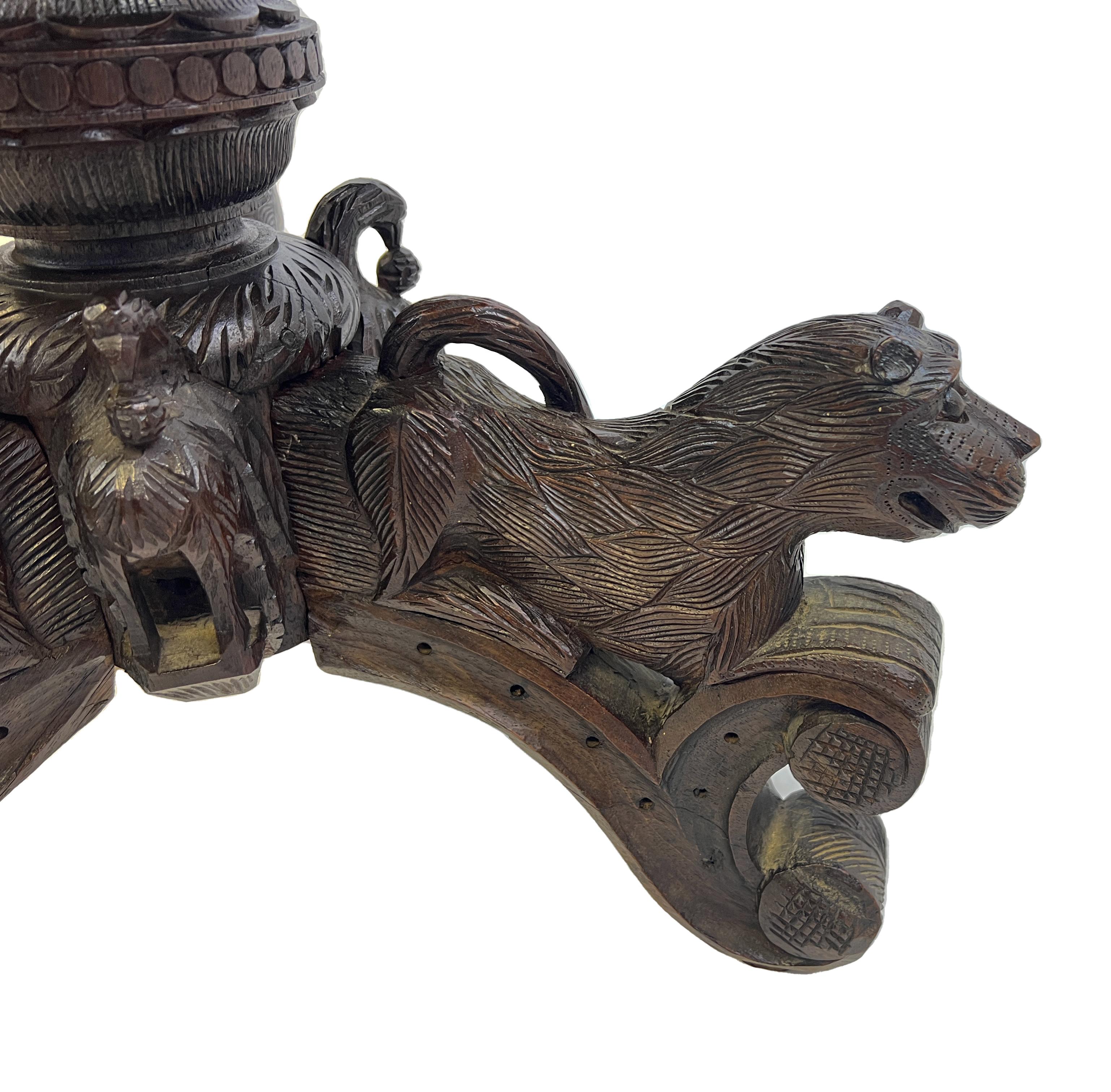 Exceptional and extensively hand-carved Anglo-Indian centre table, carved with a rope-and-vine motifs, raised on three carved lion feet.
 