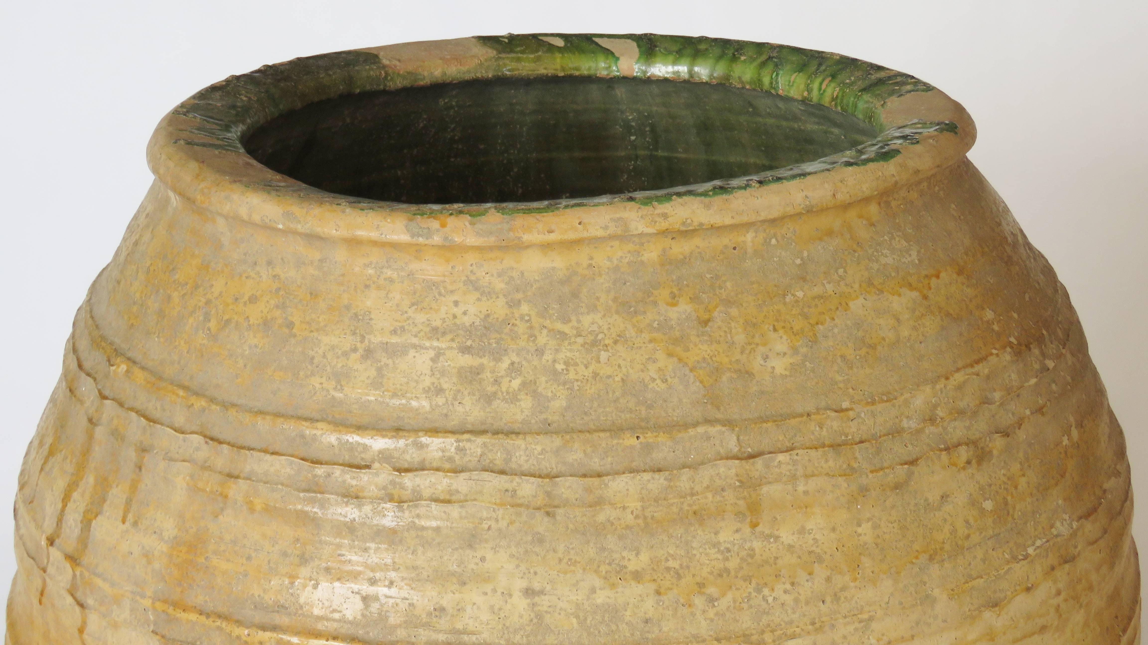 Hand coiled ceramic jar with horizontal ridging zig-zag design and barely olive green drippy glaze. Beautiful patina. Mouth: 15 1/2
