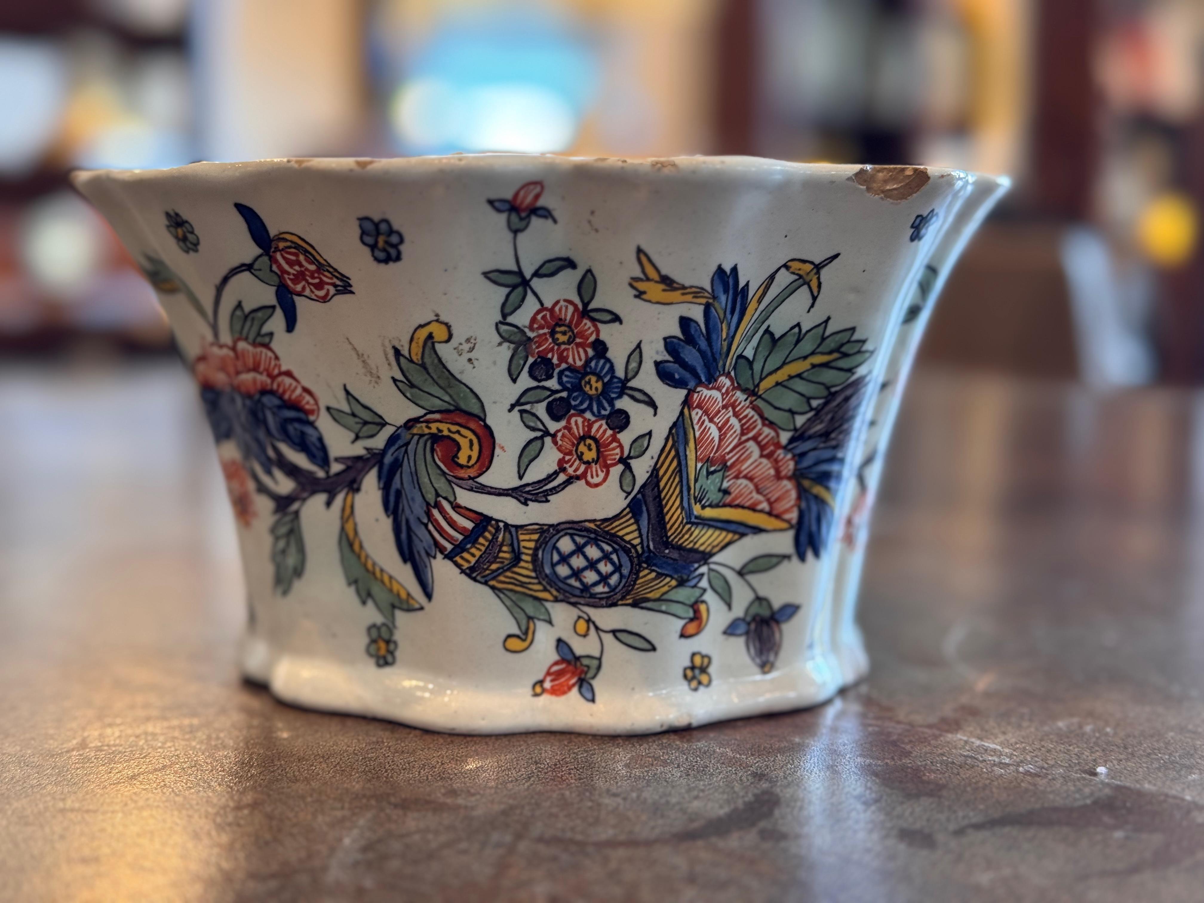 Grenouille en céramique de faïence, conçue pour arranger les fleurs avec précision et élégance. La partie supérieure festonnée comporte plusieurs ouvertures pour les tiges, tandis que le réservoir ouvert à l'arrière permet de stocker de l'eau, ce