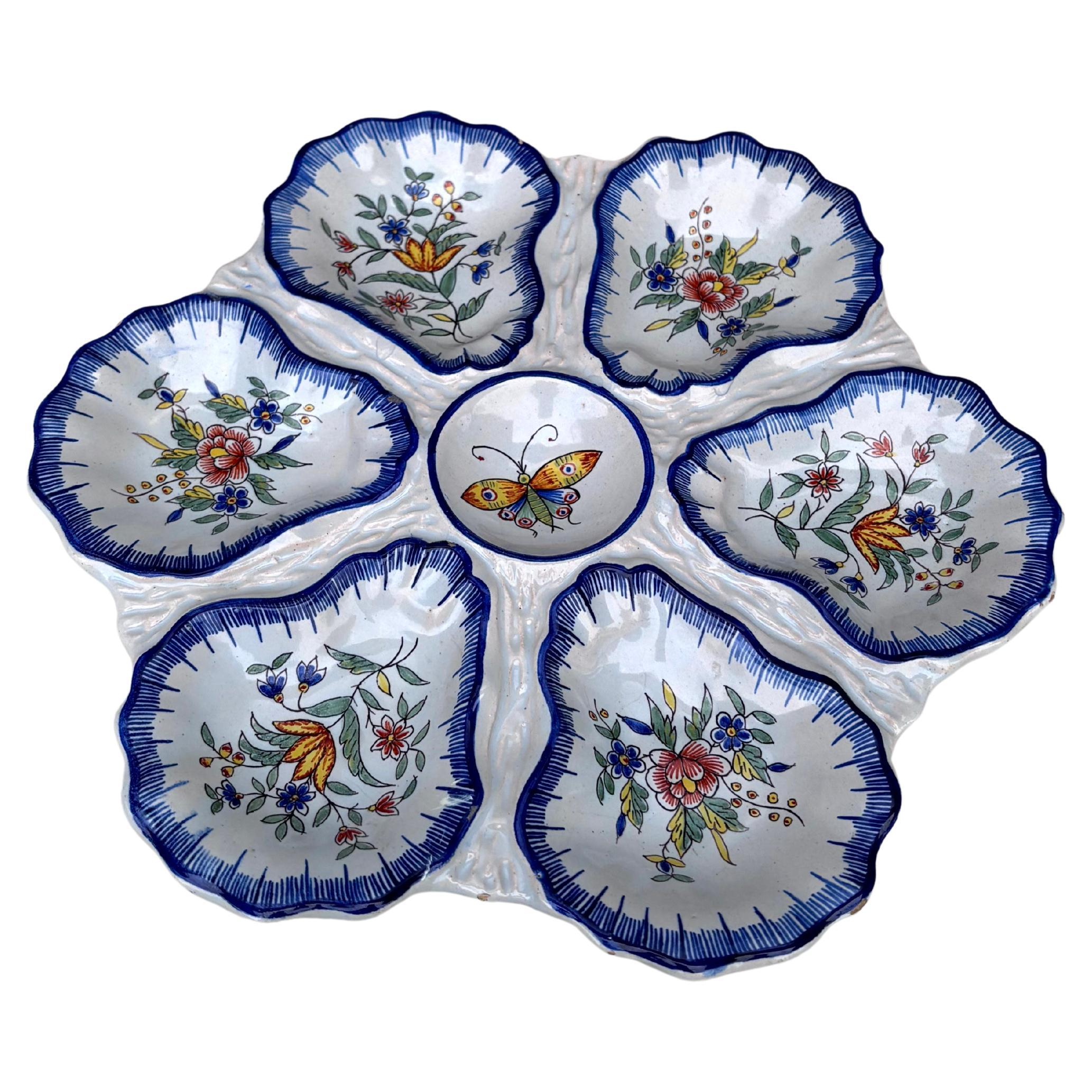 Raro e inusual plato de ostras francés, de loza, firmado Fourmaintraux Desvres, hacia 1890. Mariposa en el centro rodeada de seis pocillos con motivos florales.
Astilla en la espalda ( foto )
