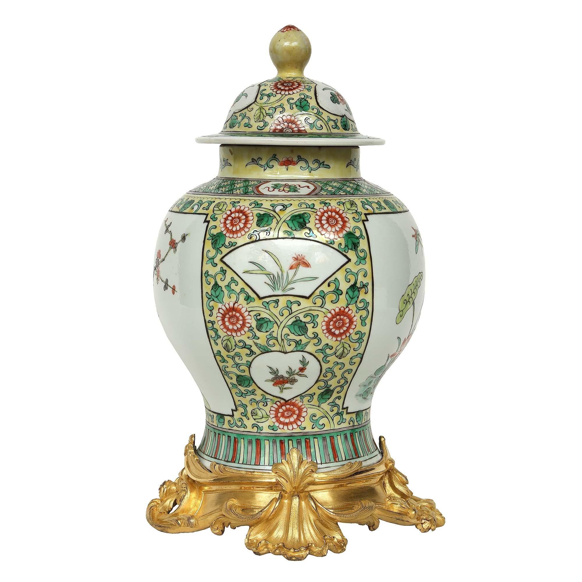 A very decorative 19th century Famille Verte Chinese porcelain lidded urn. The urn has a wonderful design of water lilies with butterflies and assorted foliage amidst a yellow background with a scrolled foliate design.

