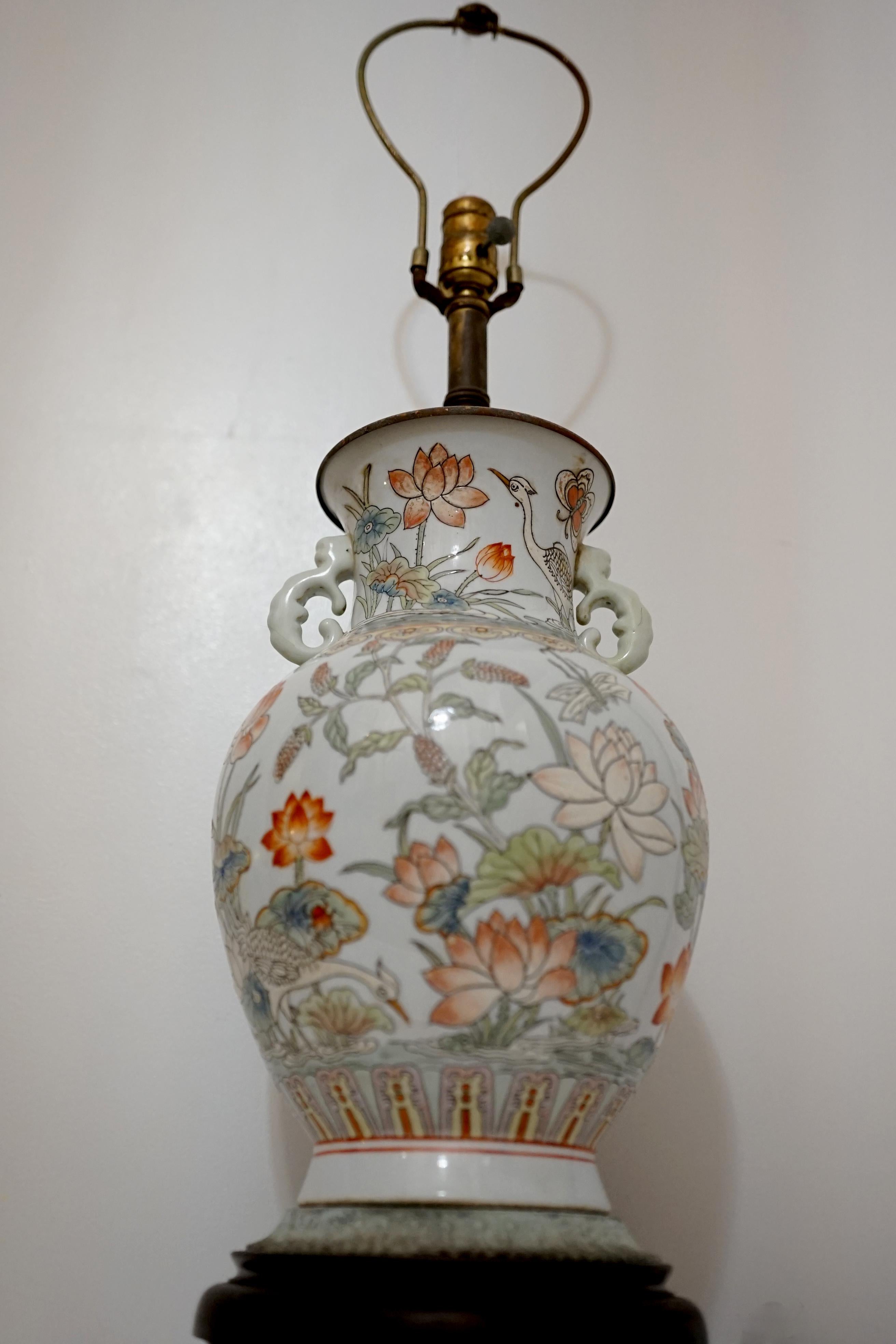 The color palette, the size and the fine artwork on the surface of this late 19th century lamp make it stunning. This lamp has everything. Of circular section and baluster form with flaring rim, tall neck with exquisite pierced handles or ears, the