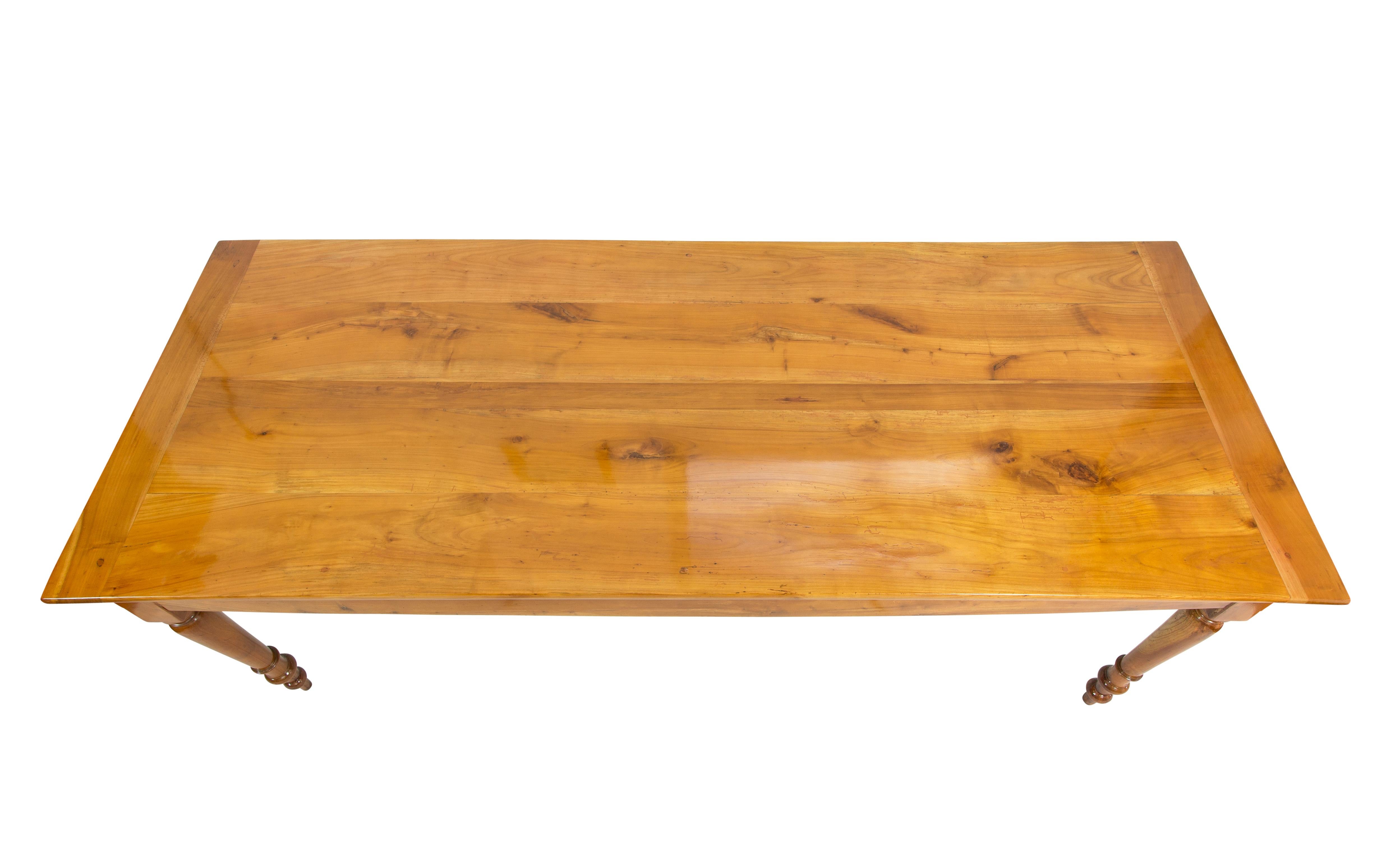 Farmhouse table in solid cherrywood, dating from the late Biedermeier period around 1850, with a drawer (cherry / pine wood.) on one side and a pull-out top made of oak/cherrywood on the other. 
The space from the floor to the frame is 61 cm. 
The