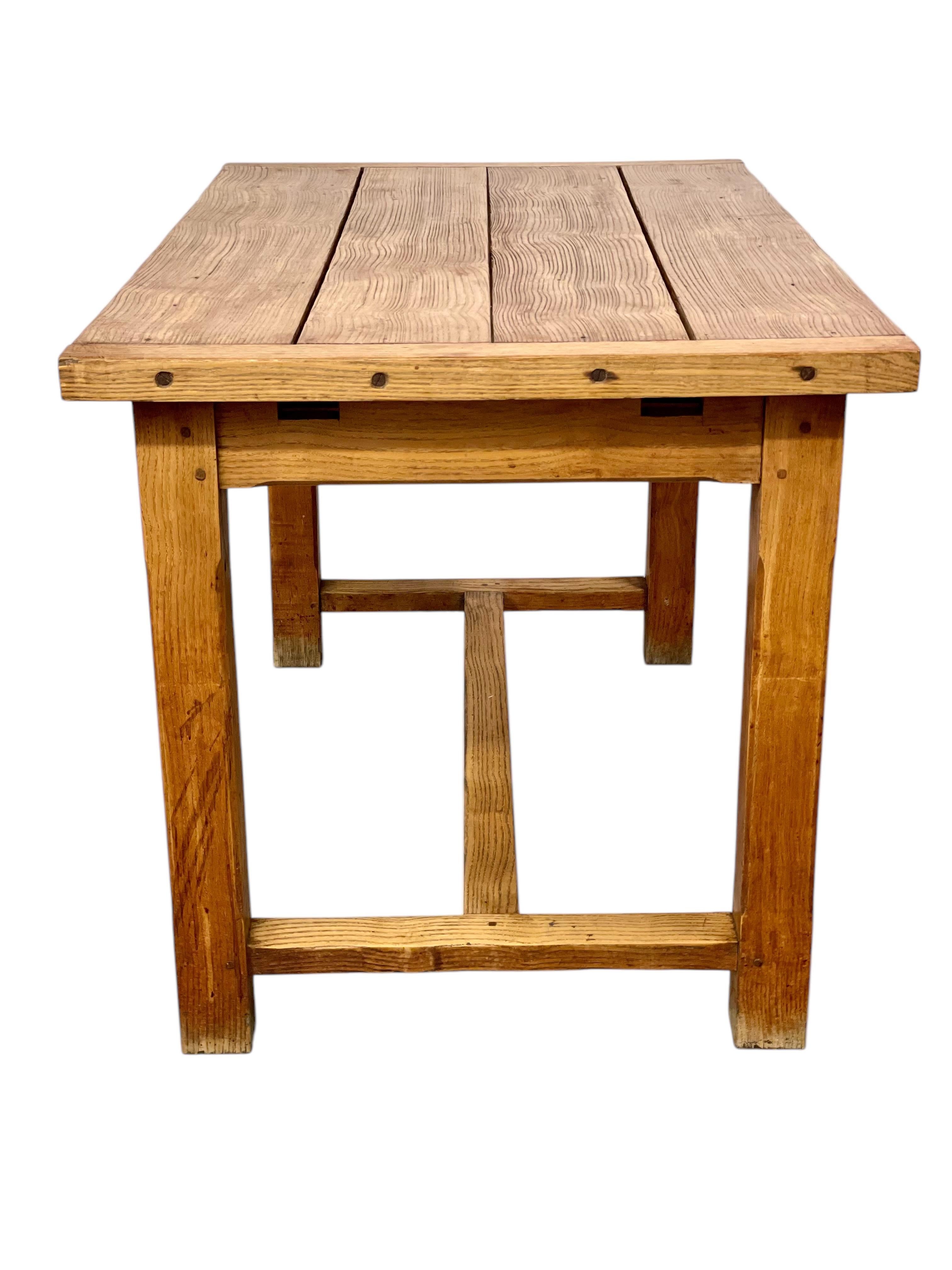 Cette petite table de cuisine de ferme date du XIXe siècle et constitue un fabuleux meuble de campagne rustique. La table est fabriquée en frêne vieilli et repose sur un châssis inférieur en forme de H. Le plateau en planches aux extrémités clivées