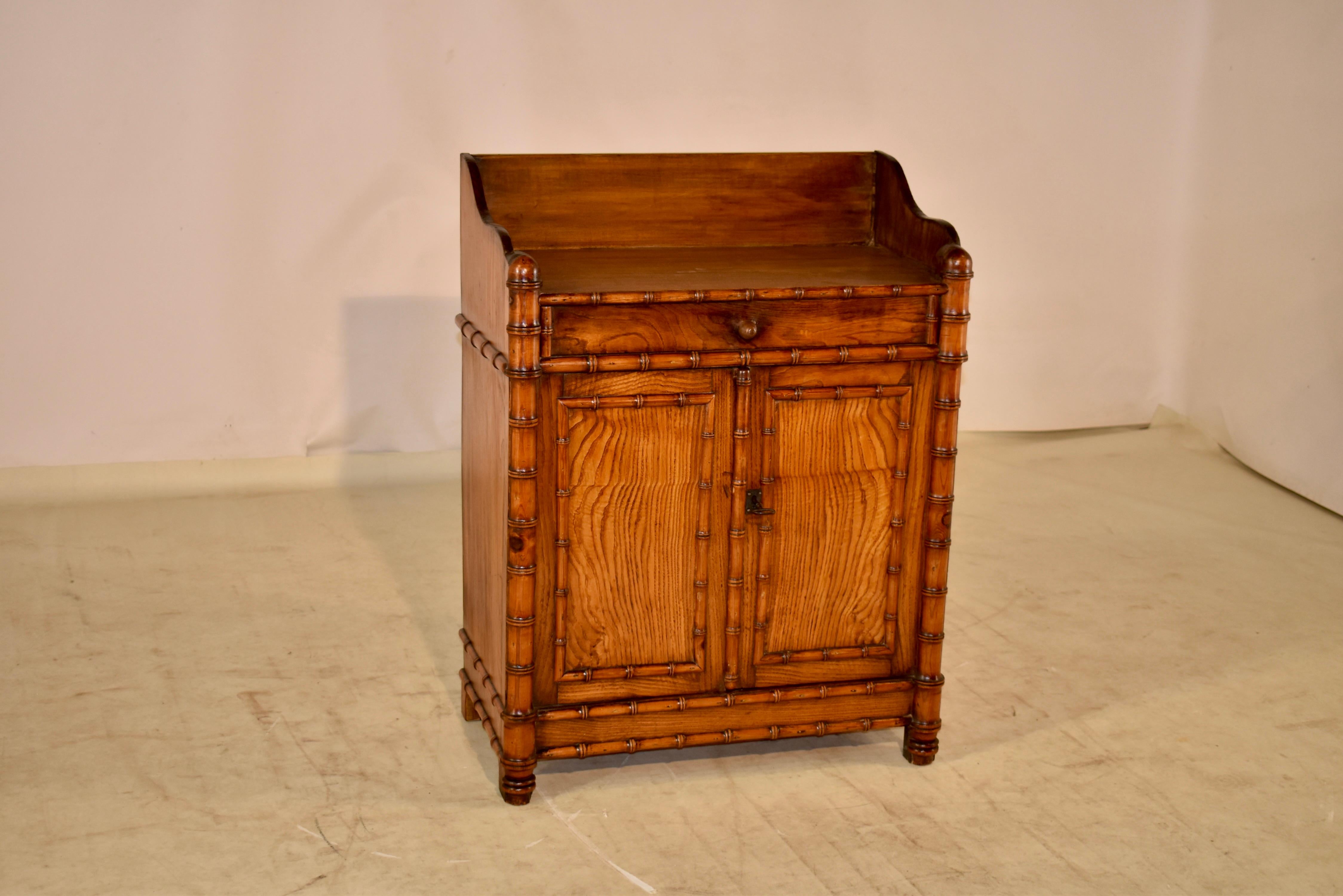 19th century small buffet from France, made from elm and cherry. The cabinet is a lovely small size and has a backsplash, which gives it a more stately appearance and has serpentined detail as well, following down to simple sides. The sides are