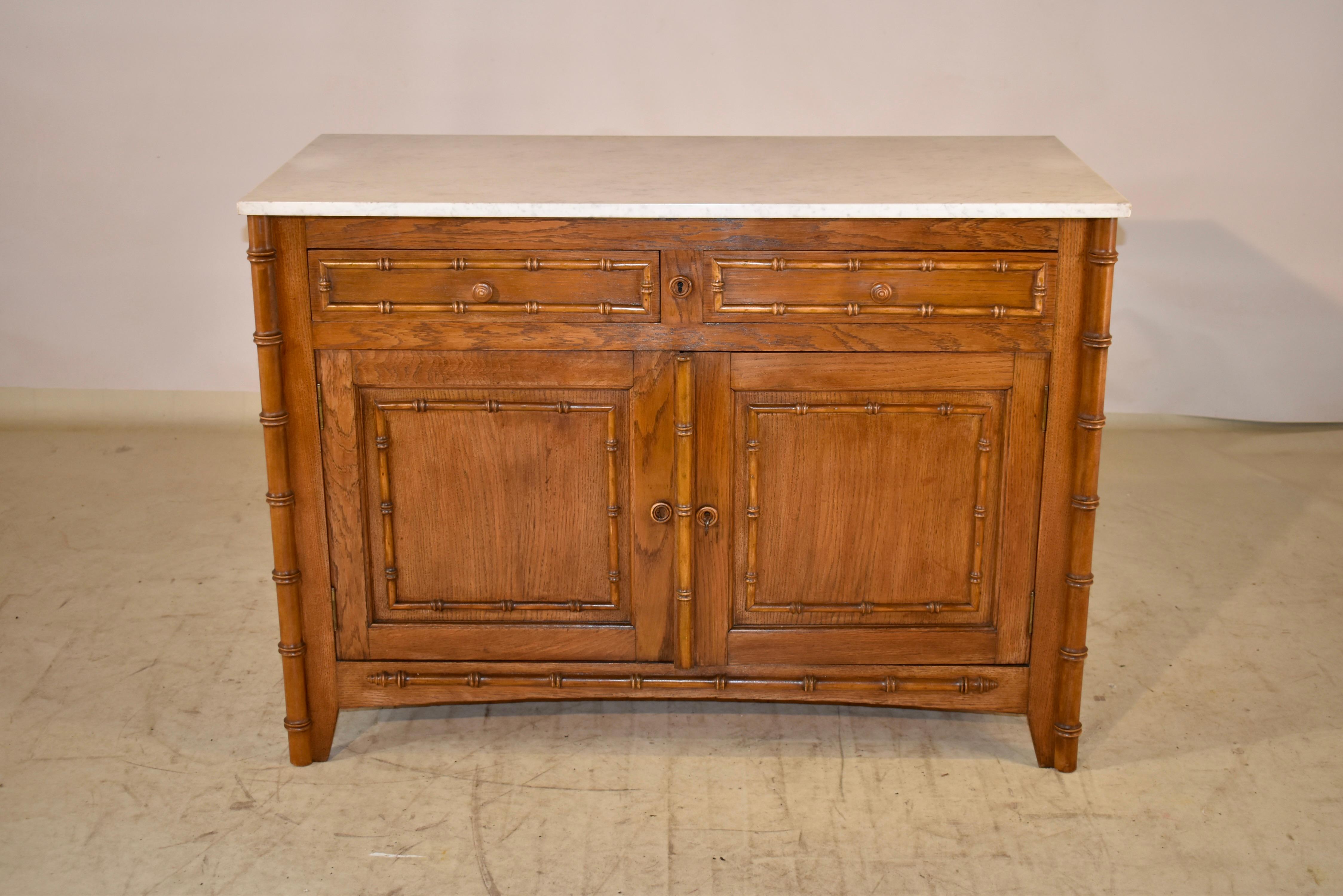 19th century faux bamboo buffet with a Carrara marble top from France.  The top has a lovely matrix and is a nice neutral color to compliment any decor.  The case has paneled sides, which is a great design feature seen from either side of the piece.