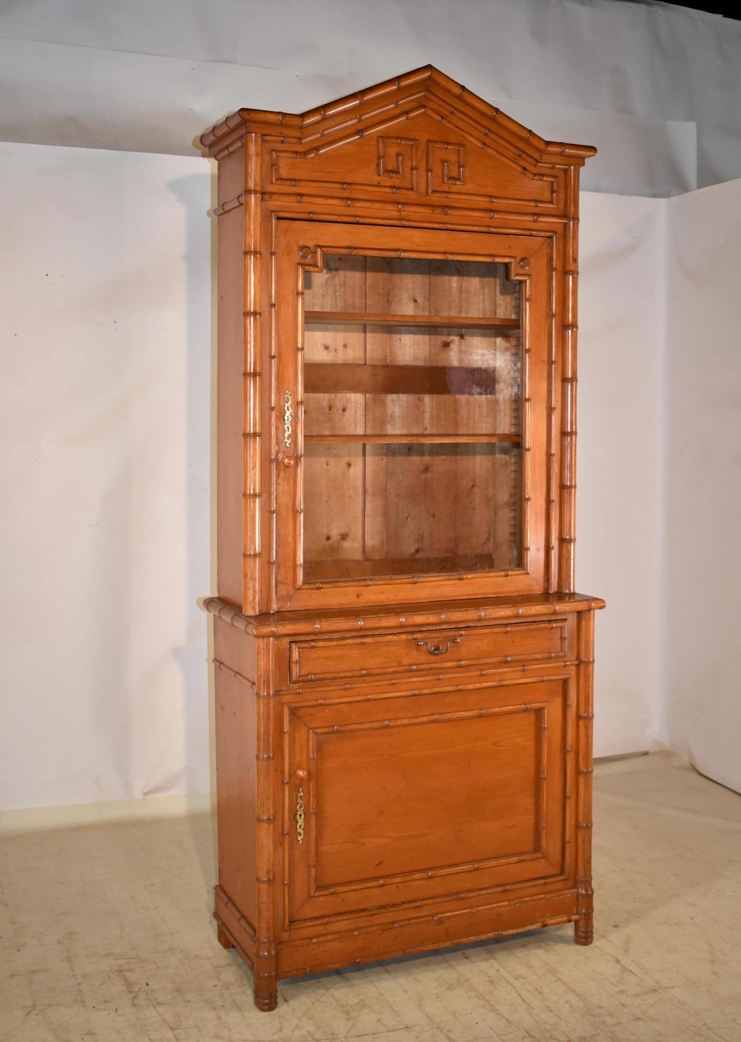19th century faux bamboo cabinet from France.  The cabinet is made from pine, and has faux bamboo molding made from cherry. The top is arched and is decorated with faux bamboo molded trim, which accents the design of the cabinet and adds interest. 