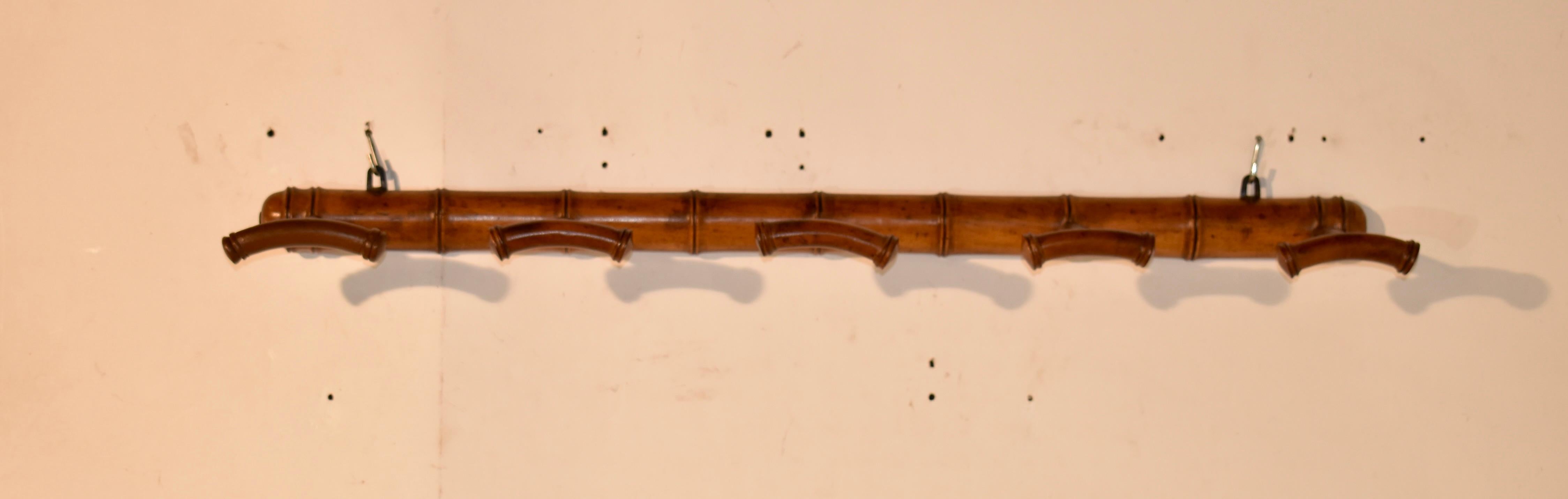 Late 19th century faux bamboo hat or coat rack from France.  The rack hangs on the wall on what appear to be the original hangers.  The rack has five turned pegs for whatever you choose to hang from them.  Very sturdy and so charming!  Perfect for