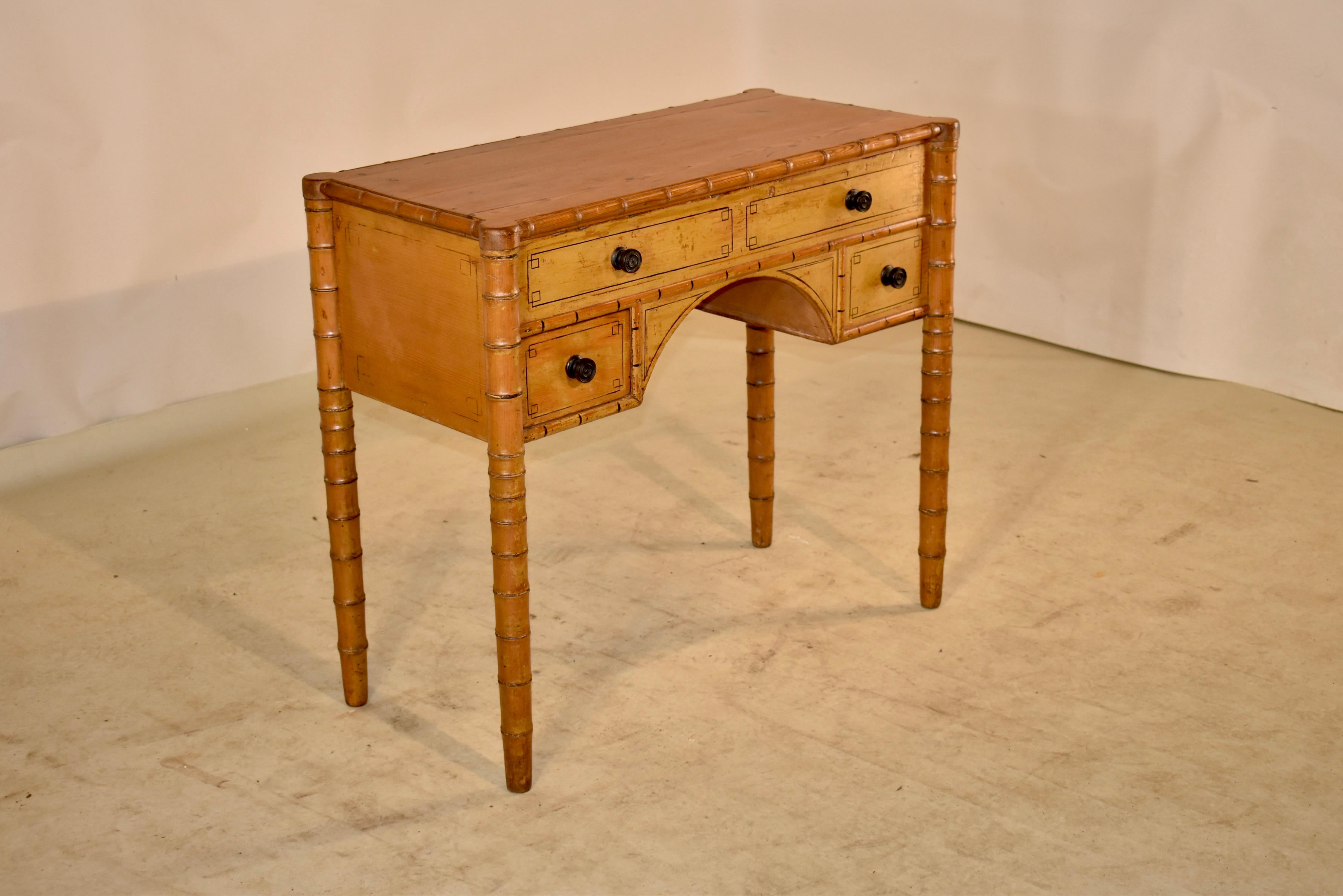 19th century pine side table from France with a shaped top and supported on four hand turned faux bamboo legs. There is one real drawer in the front and three false drawers. The sides are simple and the piece has hand painted accents. This is a very
