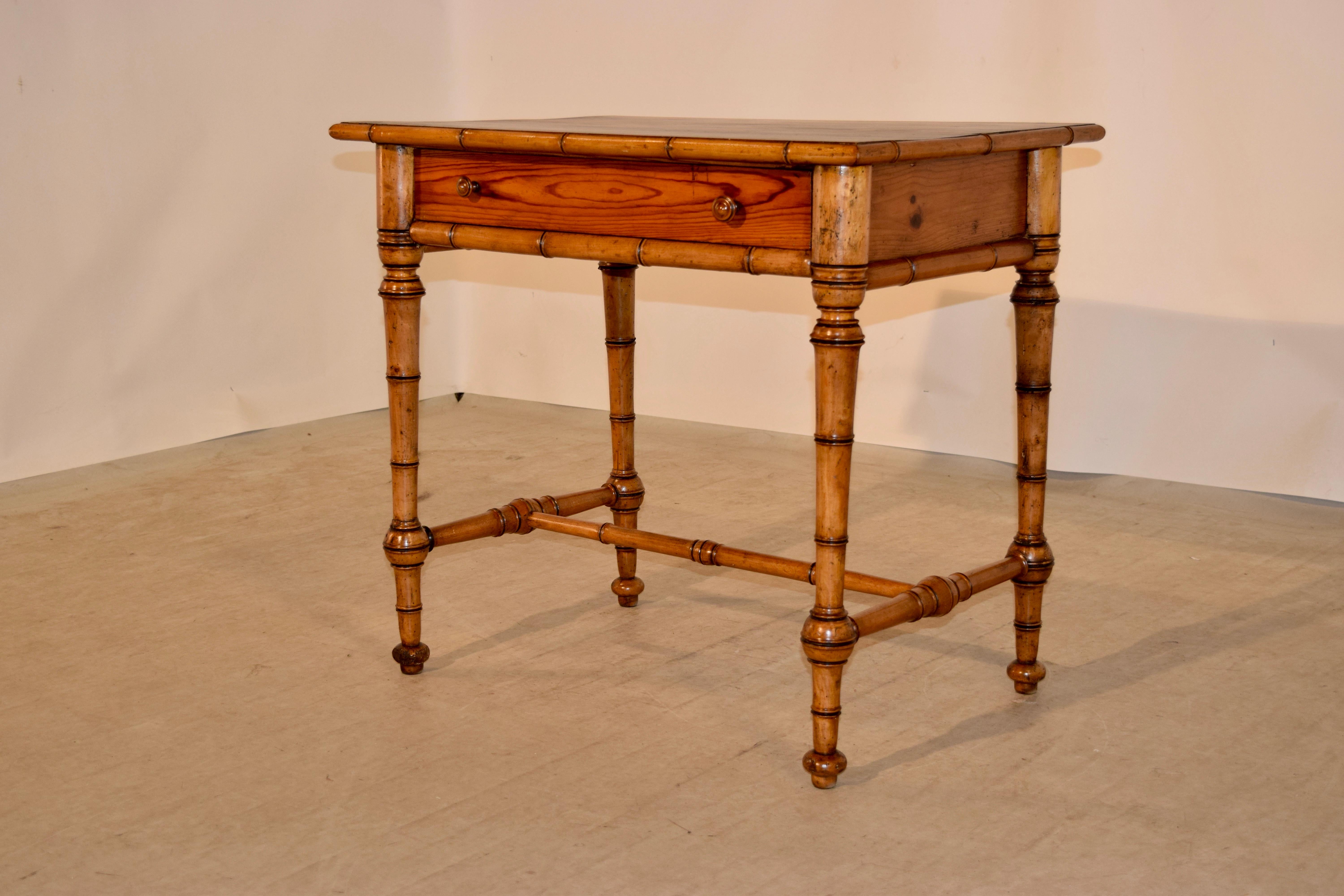 19th century faux bamboo desk with a pitch pine top which has a molded edge of faux bamboo molding made from fruitwood. This follows down to a single drawer and simple sides, also made of pitch pine. The legs are hand-turned from fruitwood and are