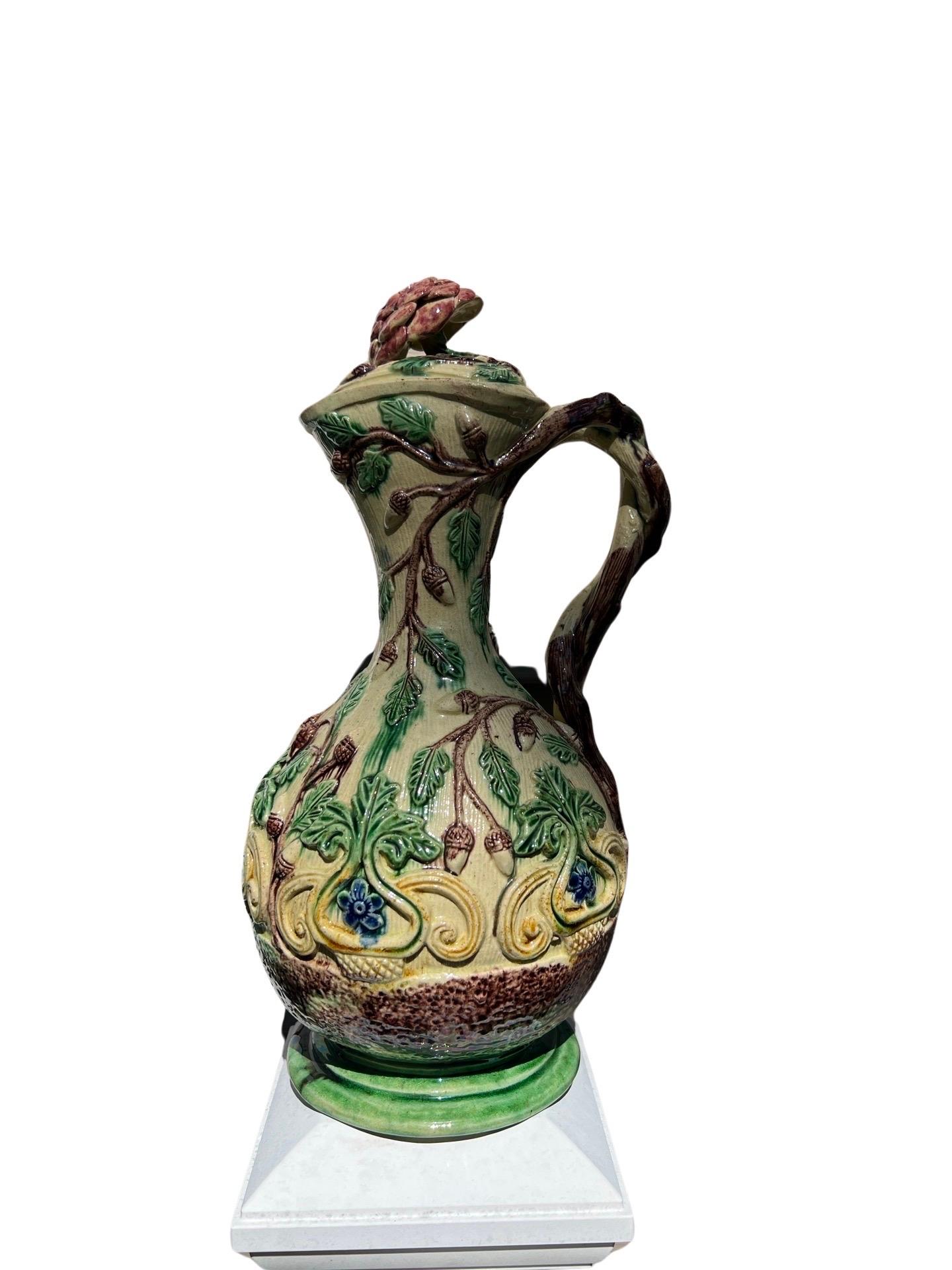 Continental, 19th century.

A finely detailed continental majolica or palissy ware pitcher. The ewer has hand applied foliate and acorn motifs the body. The handle constructed of an intertwining tree branch and a removable lid with rosette finial.