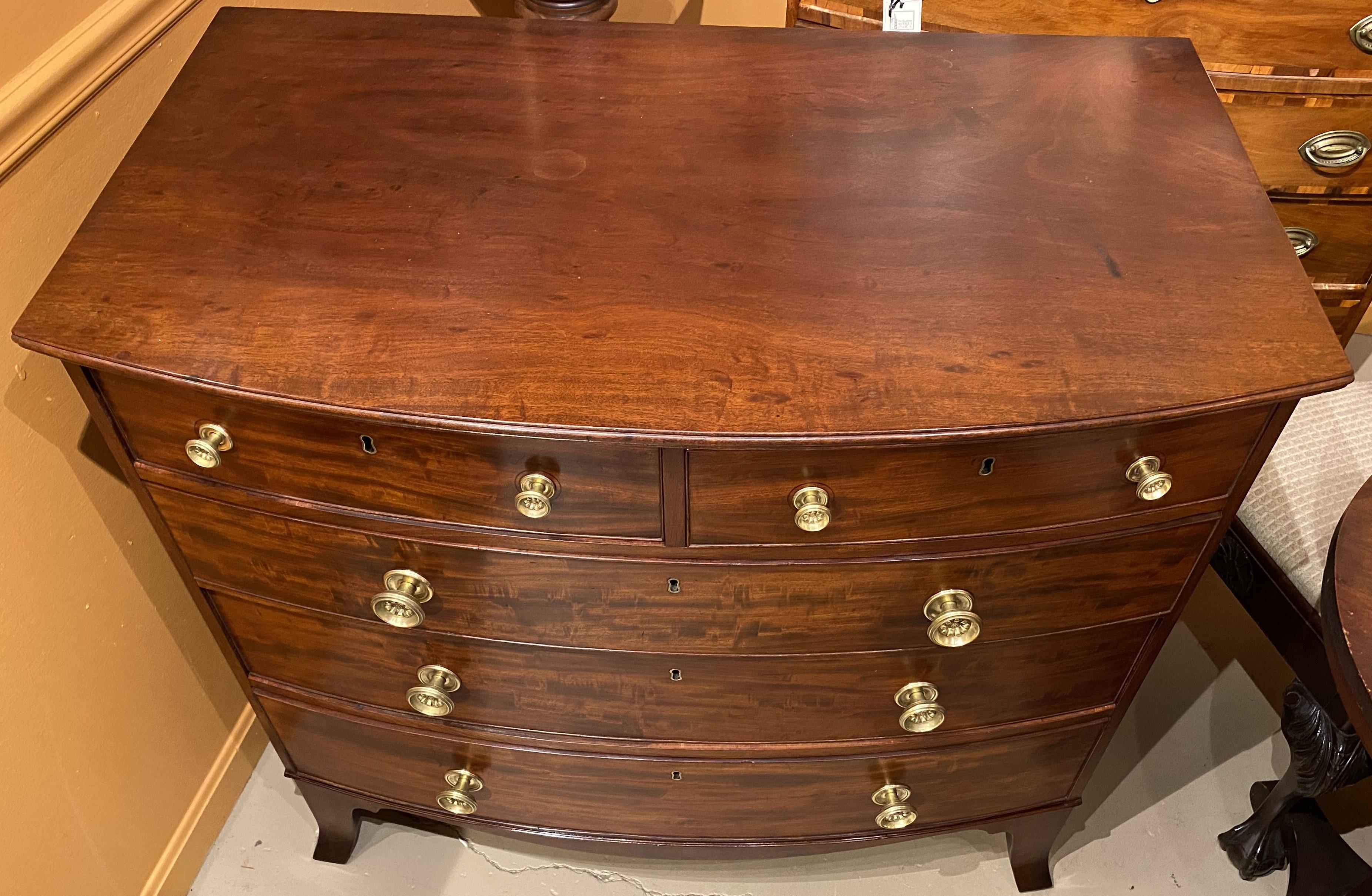 A fine example of a Federal American bow front chest in mahogany with conforming molded edge top, surmounting a case two over three drawer configuration, each with dovetailed construction and punched brass pulls,nicely shaped skirt and supported by