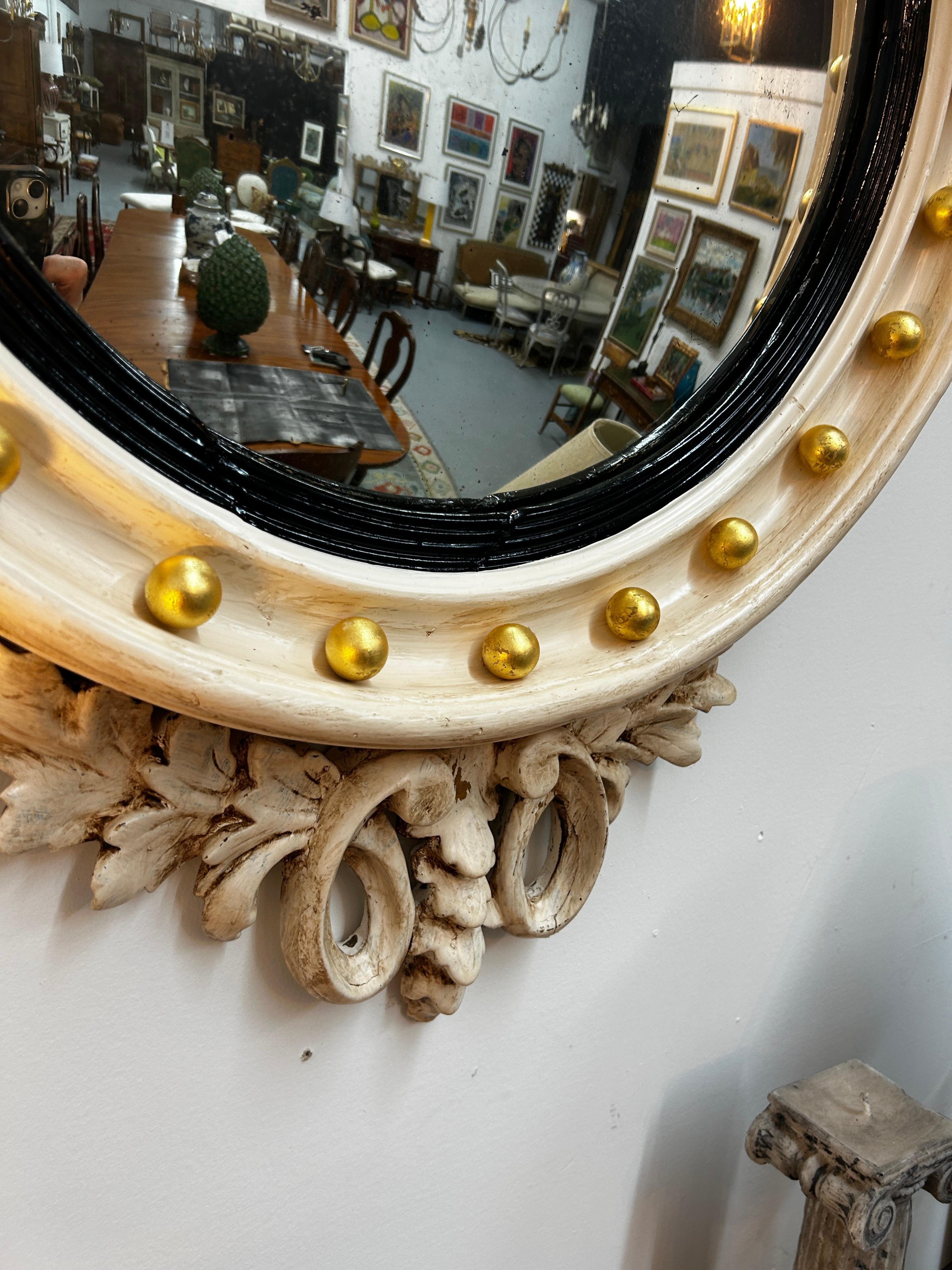 Cet exquis miroir à œil de bœuf de style fédéral américain du XIXe siècle est un exemple frappant de l'artisanat et du design classiques. Doté d'un cadre soigneusement restauré, il a reçu une nouvelle couche de peinture ivoire et un glacis subtil