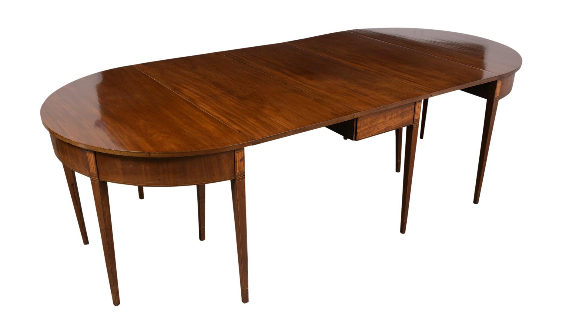 This Late 18th Century Federal Extendable Oval Dining Table is in good condition, can be arranged as a roundtable and as end-tables. and features its original walnut stain and lustrous patina finish. The dining table is finished with tapered legs