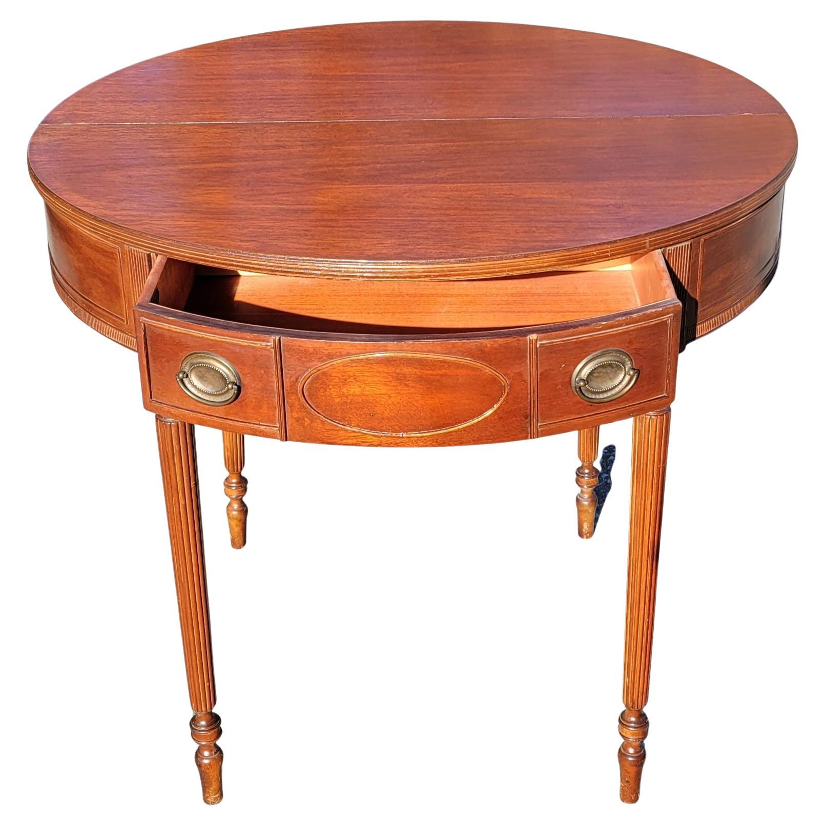 A exquisite 19th Century American Federal Hepplewhite Mahogany Demi-Lune Flip-Top Console table or Card Table in very good antique condition. Table has completely refinished recently. It features a large drawer with plenty of storage and reeded