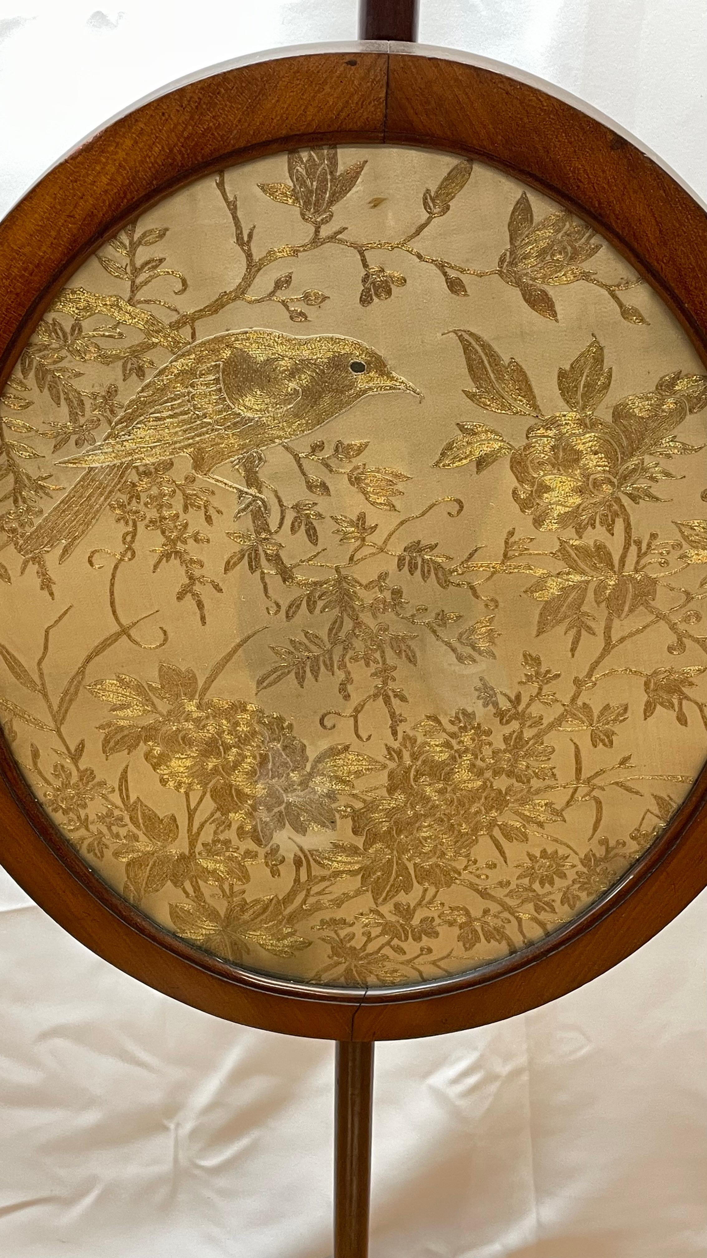 Kaminschirm im föderalen Stil des 19. Jahrhunderts mit Messingfüßen, seidengestickten Vögeln und Blumen mit Goldfäden. Hat Eichelknöpfe.

