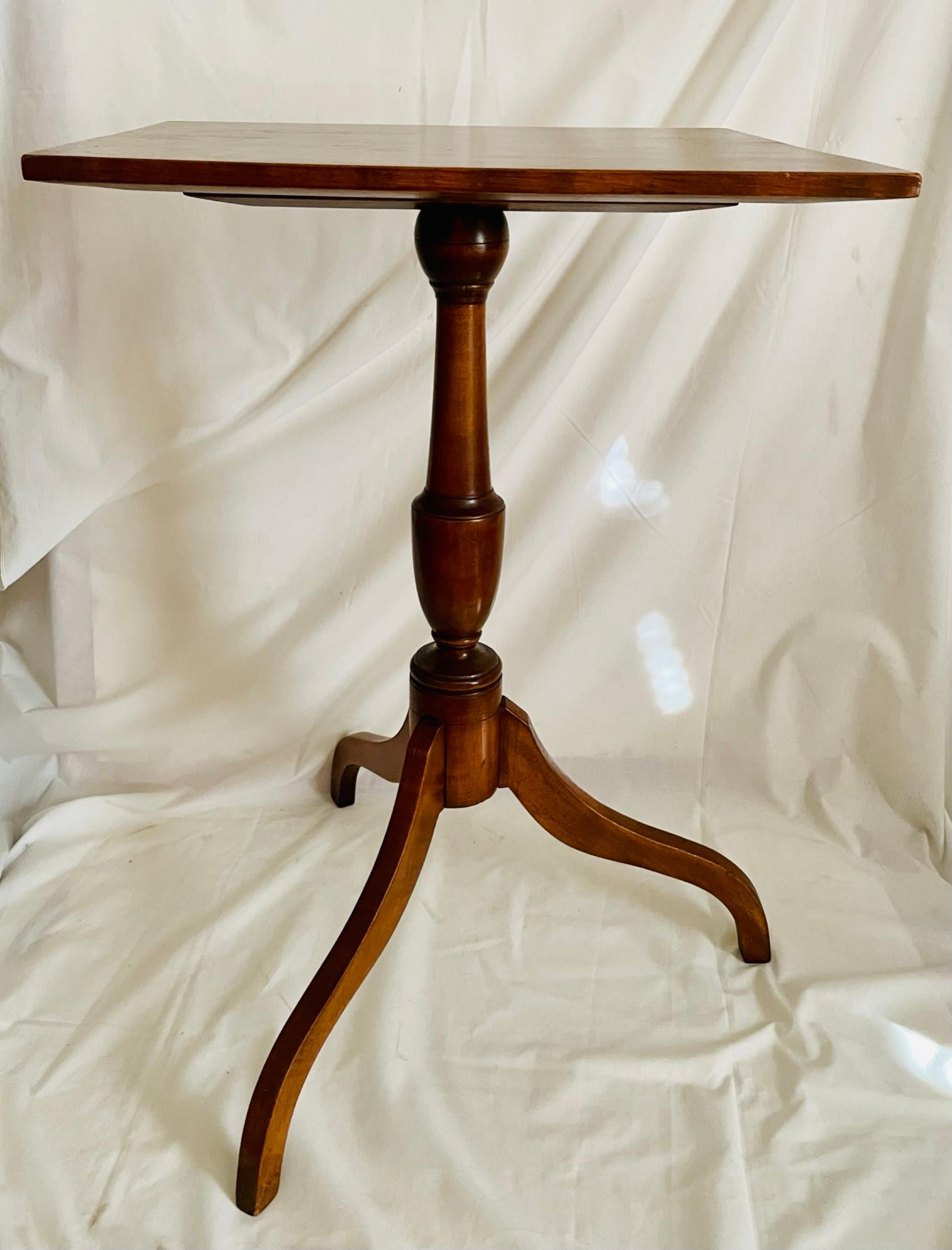 19th Century Federal Style Pedestal Side Table

This antique American square shaped top wood pedestal side table stands on three legs. The legs are attached with mortise joinery to the turned pedestal. A mounting plate with slotted screws is