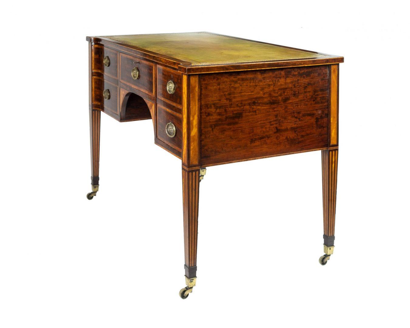 19th century figured mahogany writing desk with tooled leather inset top, the central frieze drawer flanked by a pair of cupboards, on square tapering legs inlaid with satinwood, stamped ‘Wright & Mansfield, 104 Bond Street.
Wright & Mansfield, the