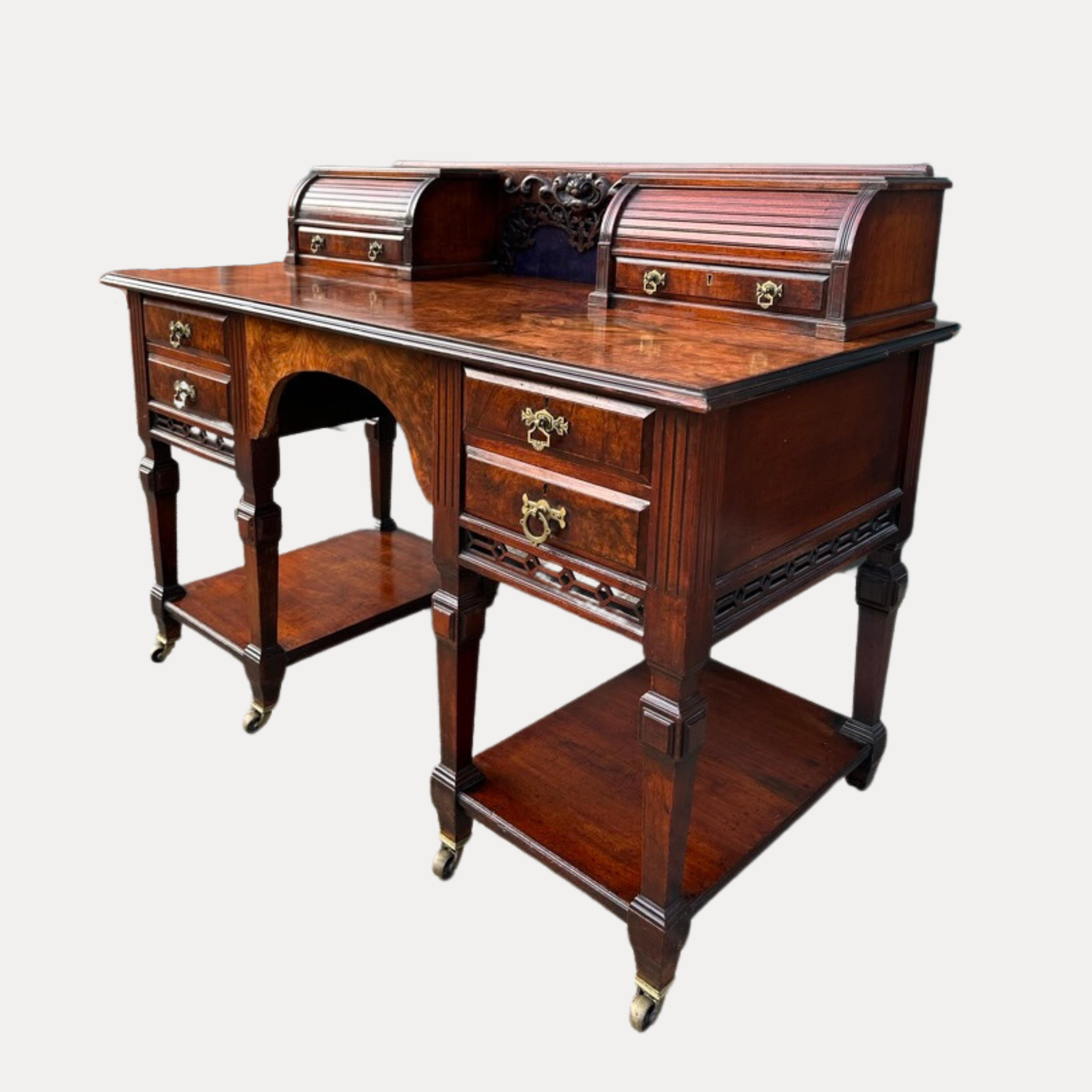 Attractive rare Victorian ladies writing desk with two short drawers below two tambour roll tops, having a highly decorative panel between, supported by a beautiful figured walnut top.
The kneehole has two drawers on either side, flanked by a