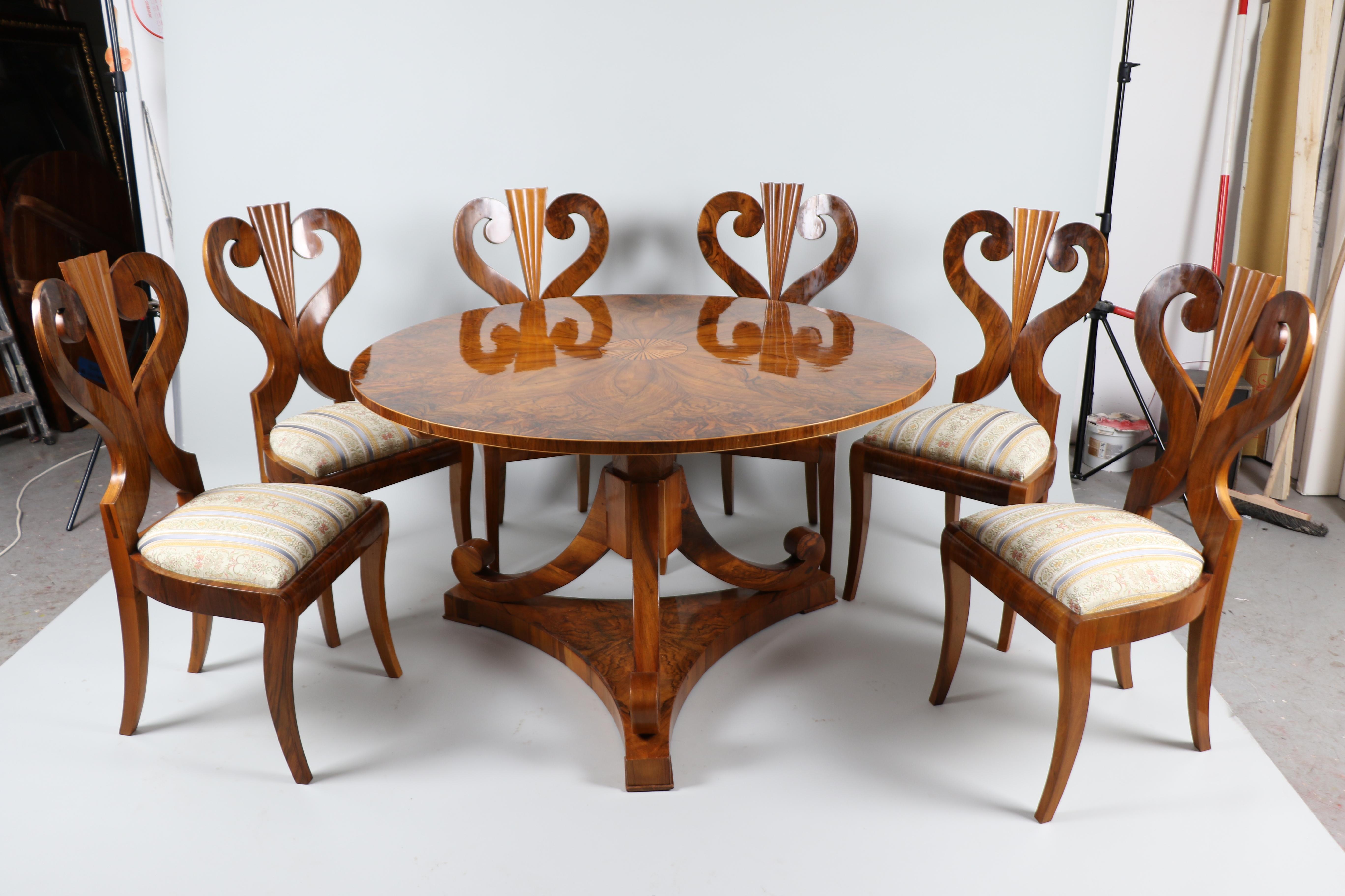 Nous avons l'honneur de vous proposer cet ensemble rare et distingué de six chaises Biedermeier en noyer, accompagnées d'une magnifique table à plateau basculant, toutes fabriquées à Vienne vers 1825. Cet ensemble de qualité muséale est un exemple