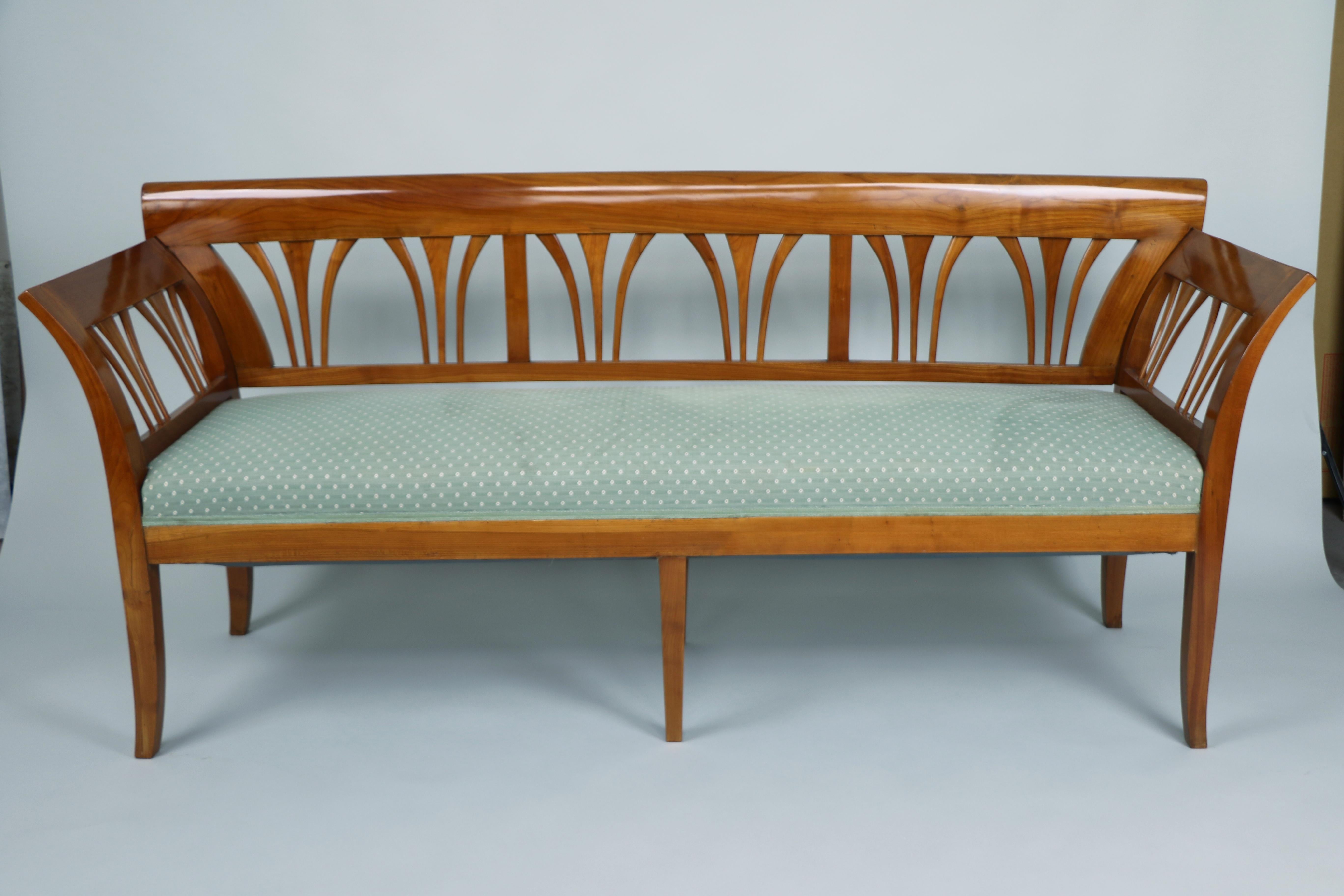 This magnificent Biedermeier bench, crafted in Vienna around 1825, is a rare and masterful example of early 19th-century design at its finest. Made of solid cherrywood—a material highly prized for its warmth, richness, and fine grain—this piece