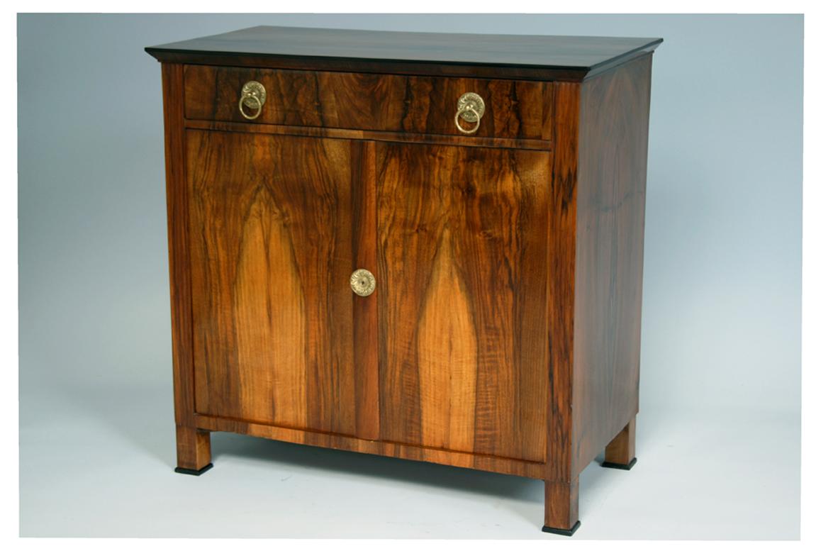 Ciao,
Questa elegante commode trumeau in noce Biedermeier è stata realizzata intorno al 1825.

Il Biedermeier viennese si distingue per le sue proporzioni sofisticate, il design raro e raffinato e l'eccellente artigianato e continua ad avere una
