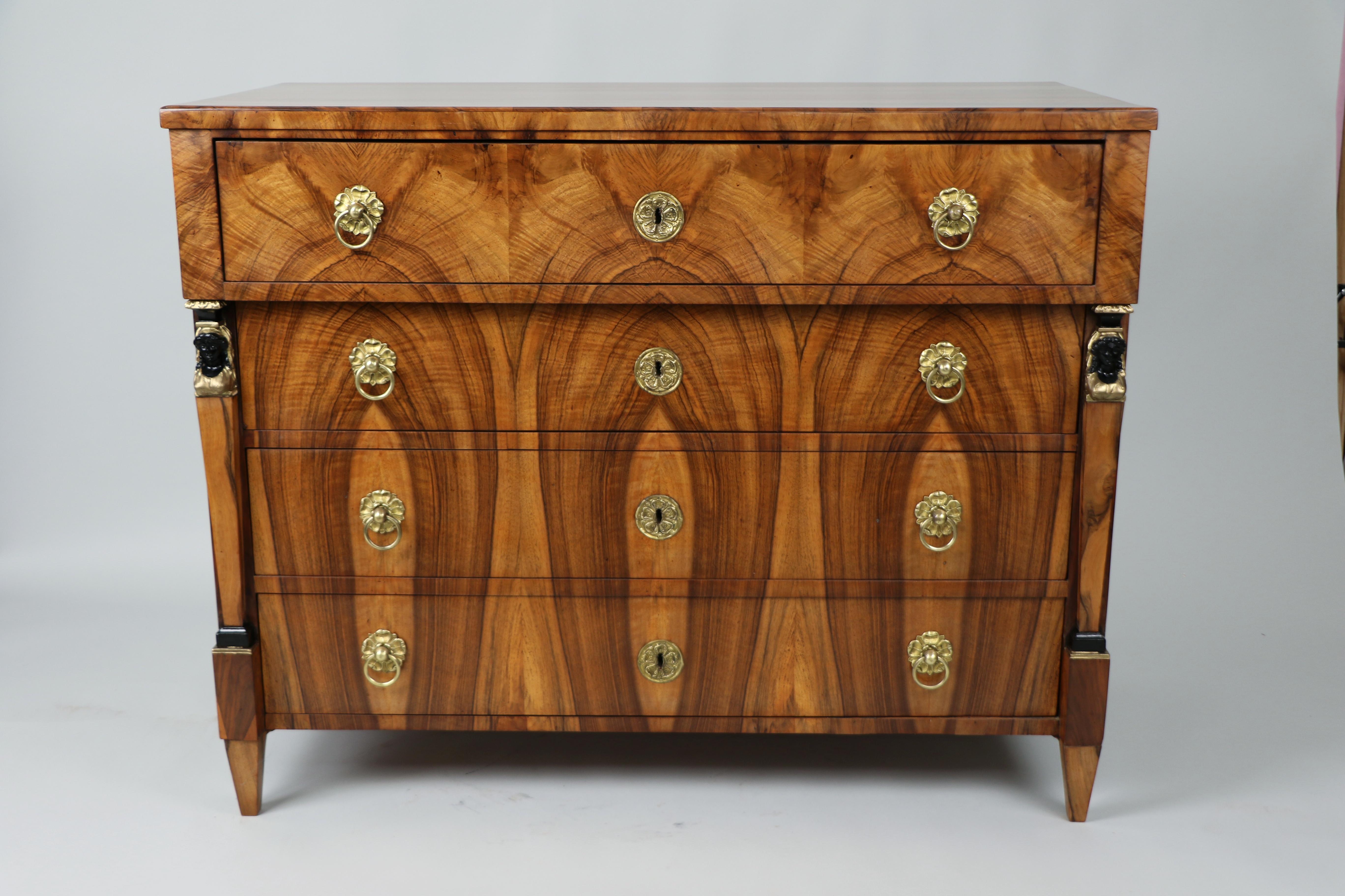 Nous avons le plaisir de vous proposer cette exceptionnelle commode à quatre tiroirs en noyer Biedermeier, une pièce extraordinaire créée à Vienne vers 1825, véritable témoignage de l'âge d'or de l'artisanat autrichien.

Ce coffre de qualité muséale