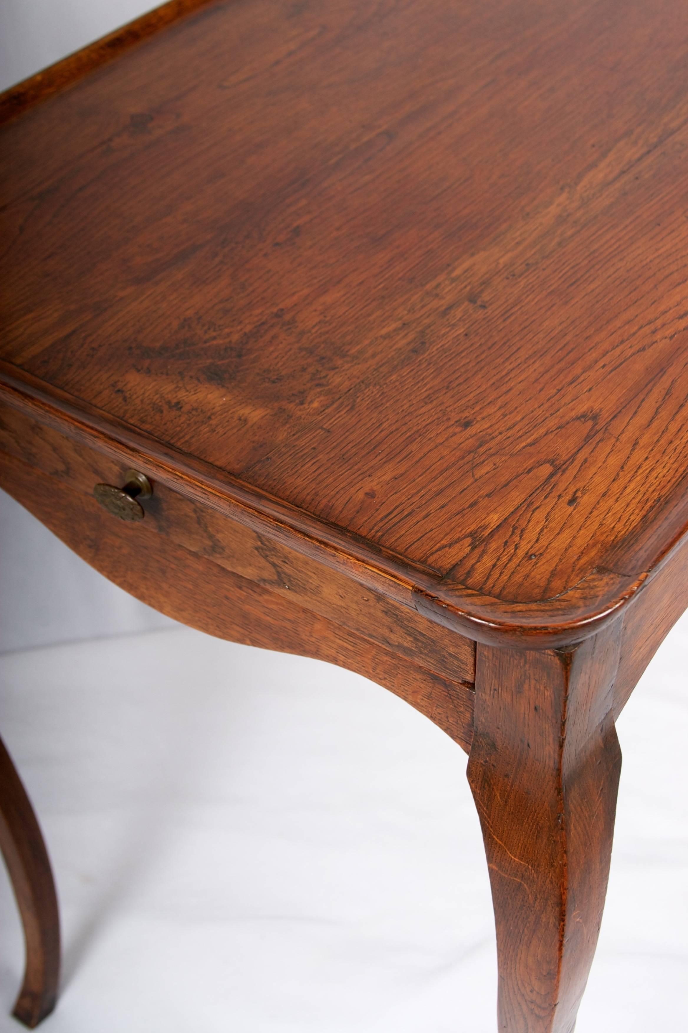 A wonderful solid oak side table with shaped dish top detail, lovely
cabriolet legs and one drawer.