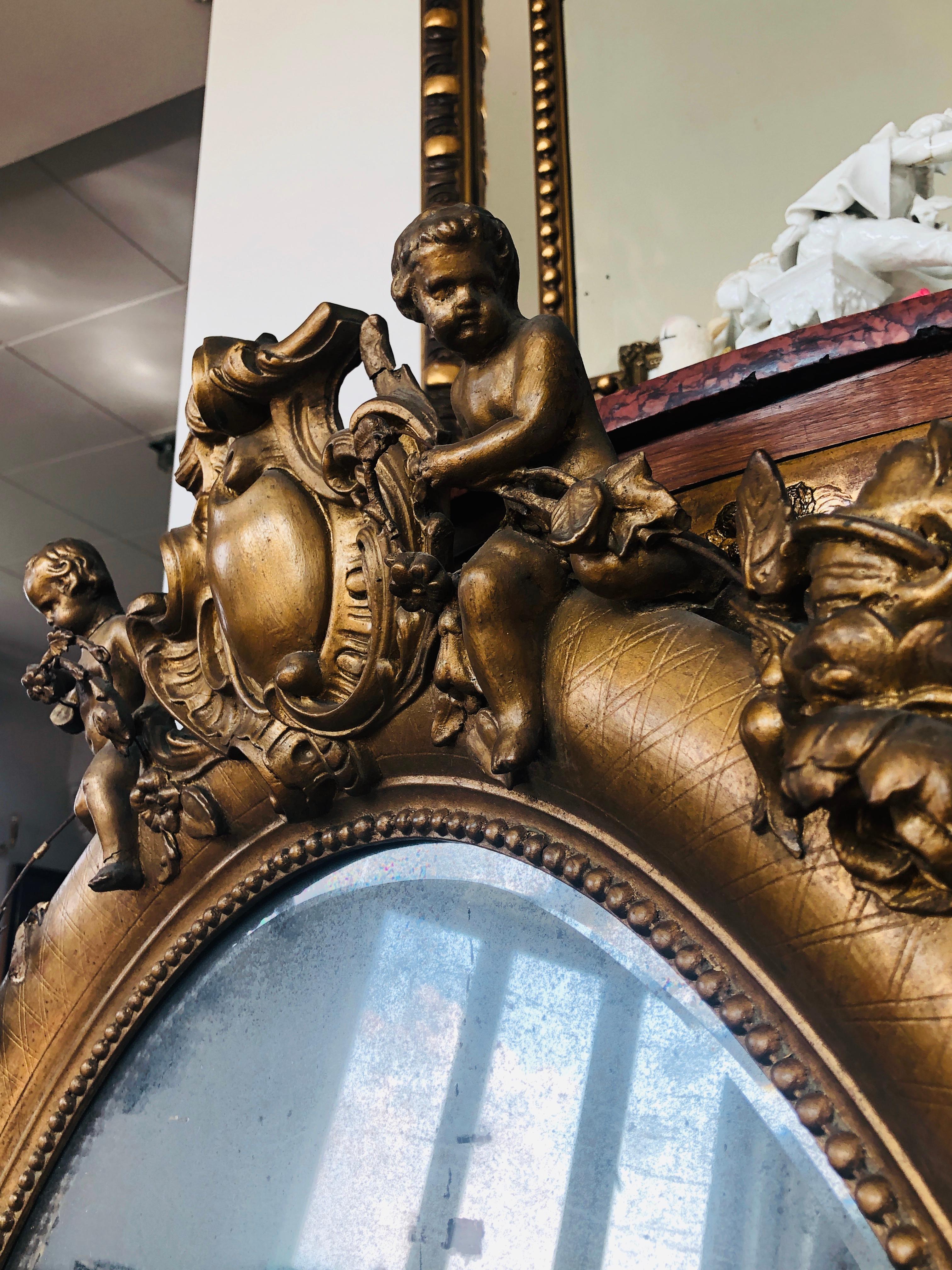 XIXe siècle Miroir ovale français du 19ème siècle en bois doré avec chérubins sur le dessus en vente