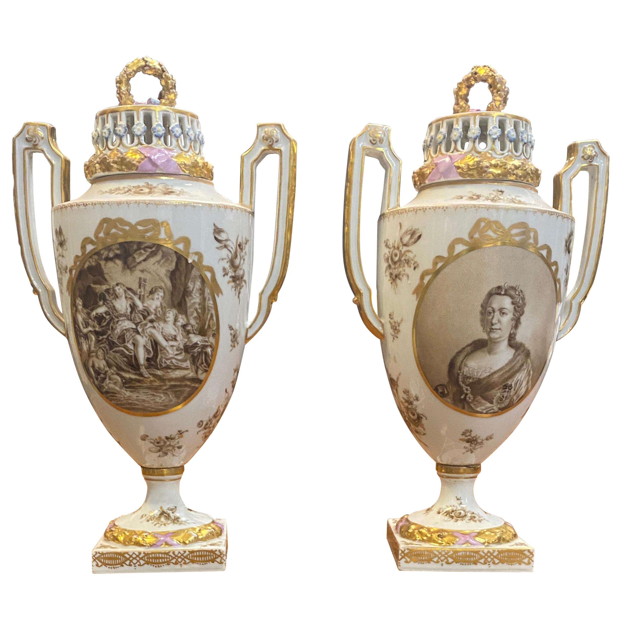 Pair of porcelain covered potpourri urns
Each with royal style portraits on front, mythological scenes on rear, stylized reticulated dome tops with wreath finials,
large handles, on pedestal bases, heavily gilded and in relief.
Measures: Height
