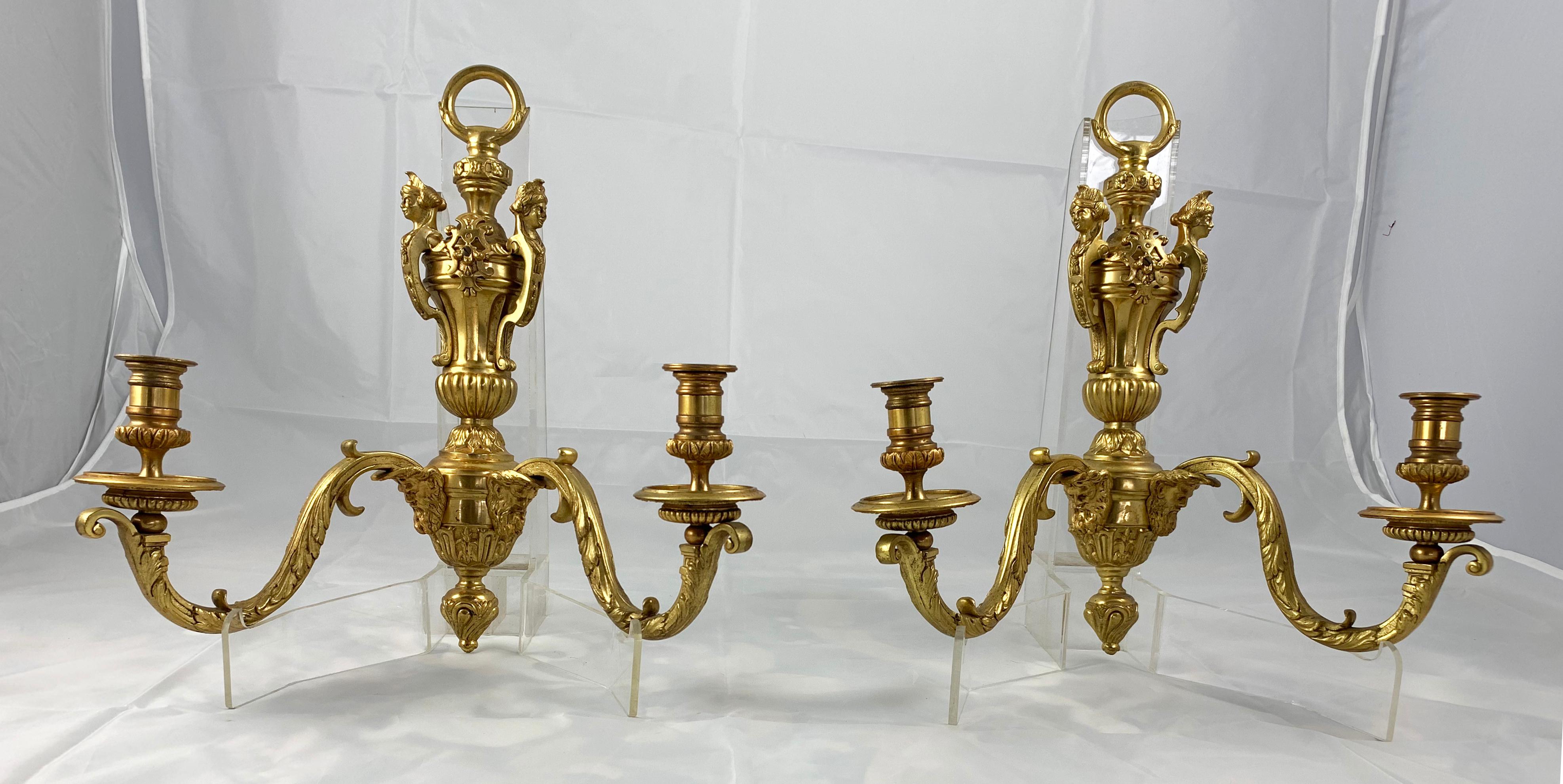 A Fine Pair of Ormolu two branch wall light, circa 1900. Each with cast foliate decoration applied with classical figures. Spool shaped sconces.