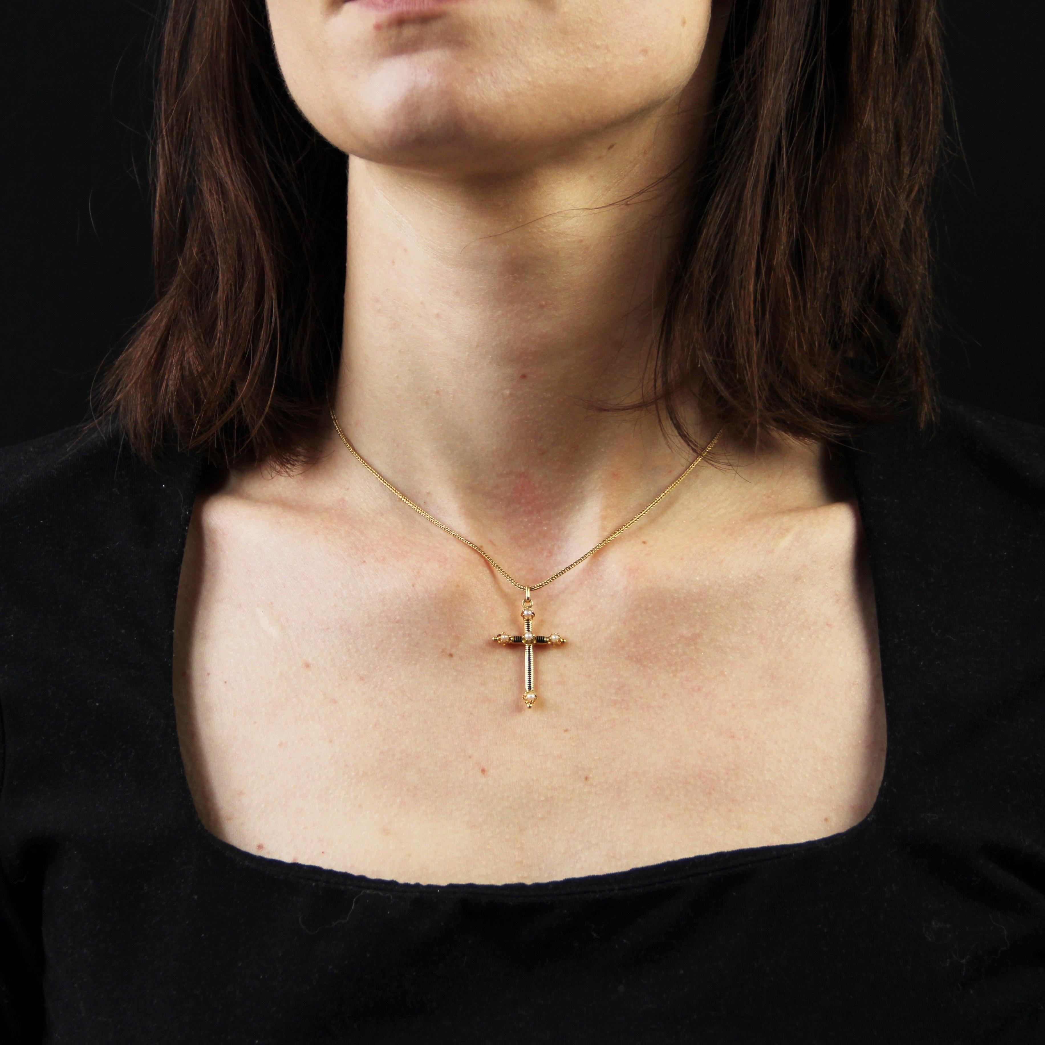 Pendentif croix et chaîne en or jaune 18 carats, poinçon tête d'aigle.
Cette ravissante petite croix antique est bombée sur le devant, décorée de filets d'émail noir et sertie de griffes aux 4 points cardinaux et de demi-perles au centre. Ce