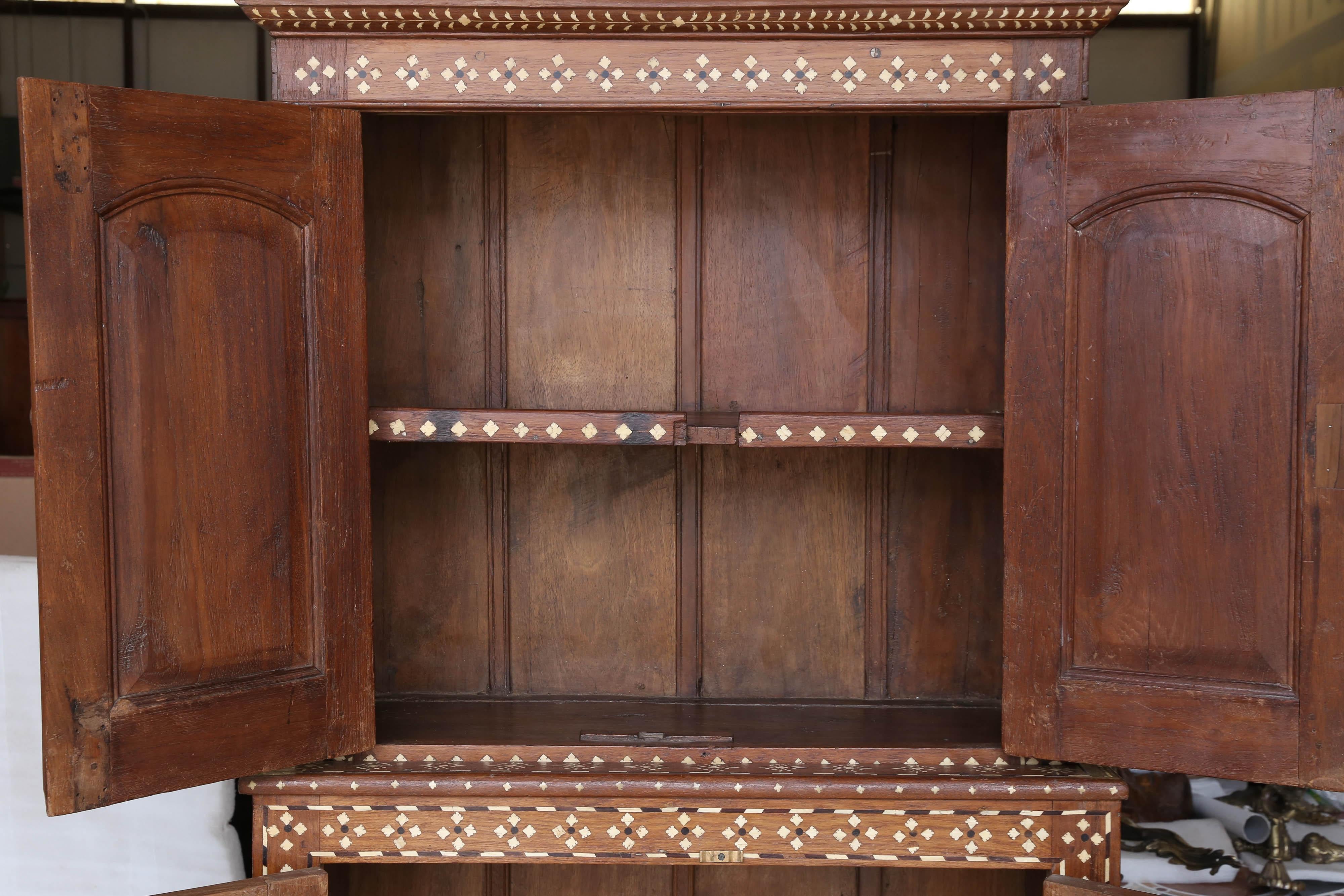 This two parts cabinet was made in high quality teak wood in the 19th century in the Coramandal coast of east India.
The hallmark of this piece is its exceptional quality of carpentry. It retains all original hardware. The inlay in bone was added