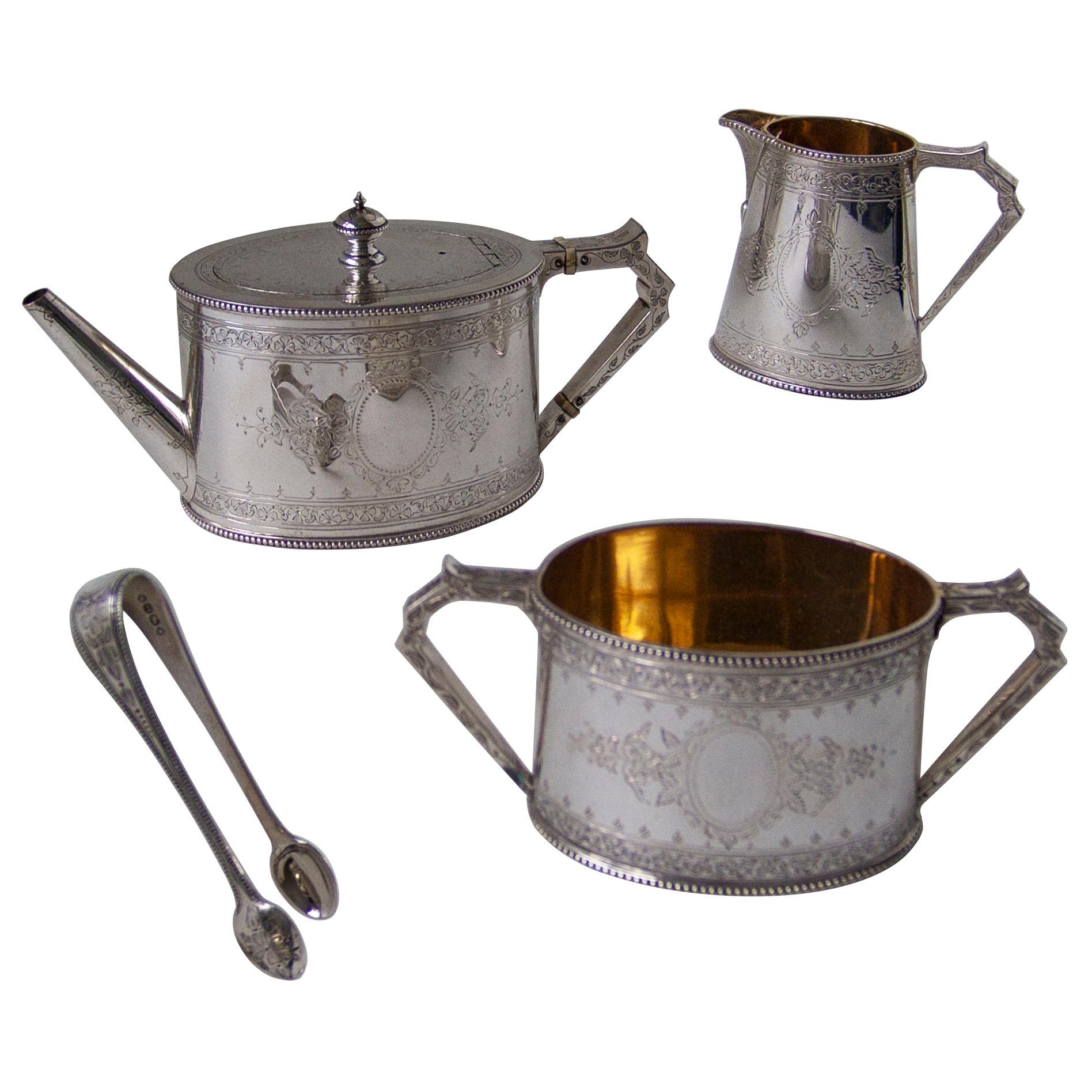A very good Victorian sterling silver can shaped tea set comprising a silver handled teapot, cream jug, sugar basin and sugar tongs all housed in original presentation case. Each piece is embellished with bright-cut engraving. The cream jug and