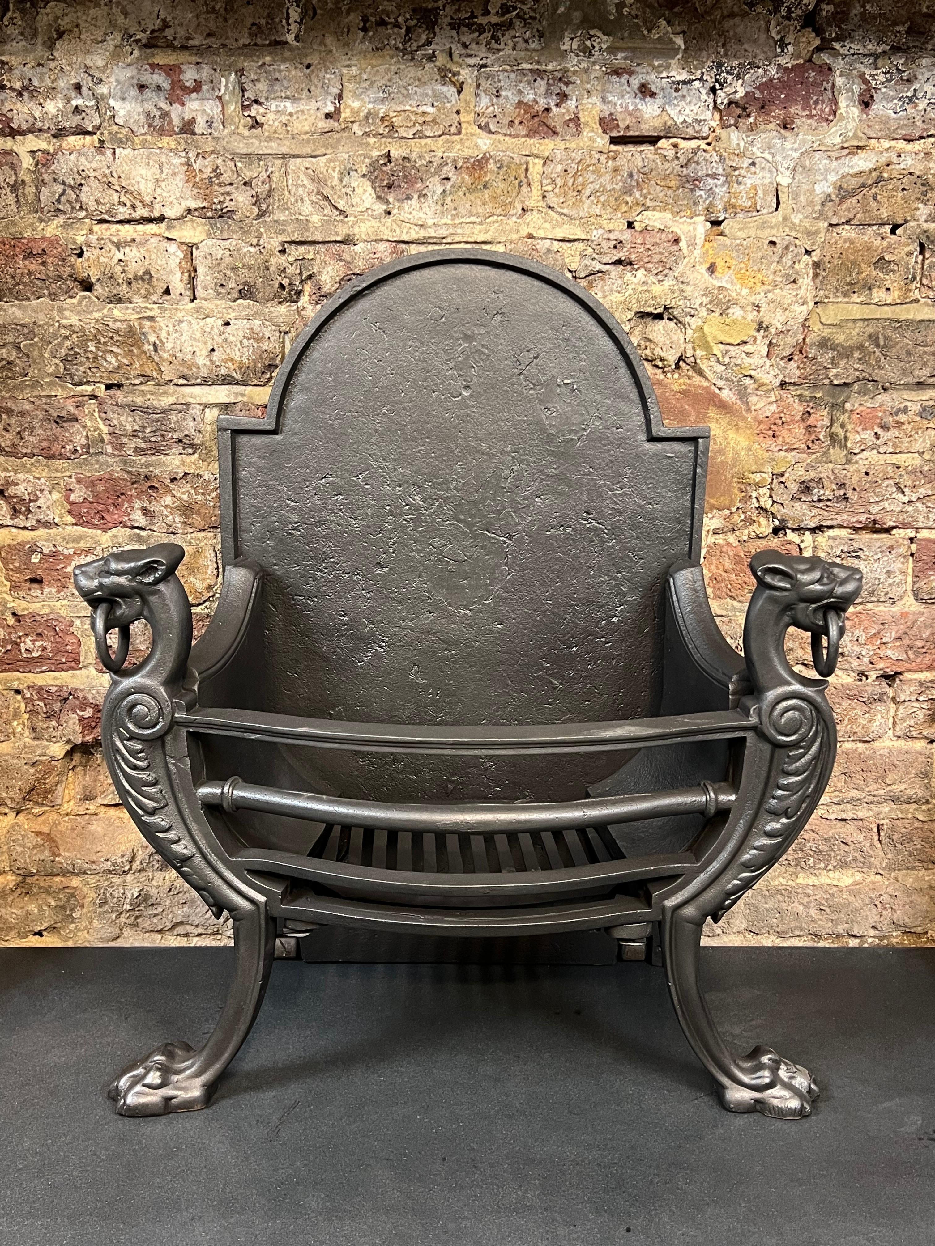 19th century fireplace dog grate. 
This antique English dog basket is finely made representing the iconic Victorian Gothic period. Its andirons cast in the form of lions with ringed mouths with lion paws at the feet, which support three horizontal