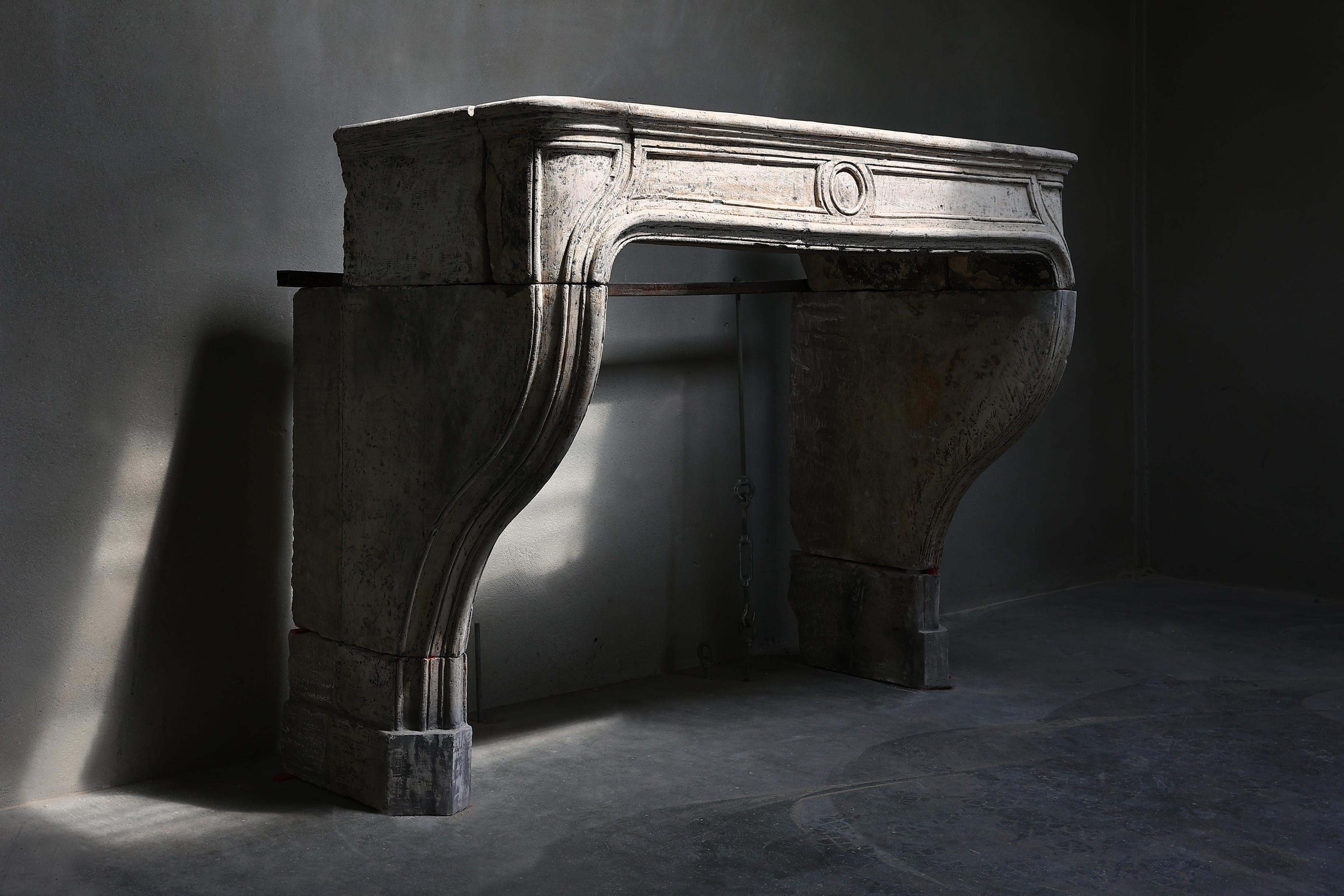 Beautiful antique fireplace in the style of Louis XIV made of French limestone. This fireplace from the 19th century has a nice size and warm color scheme. The various ornaments and lines in this fireplace provide elegance!