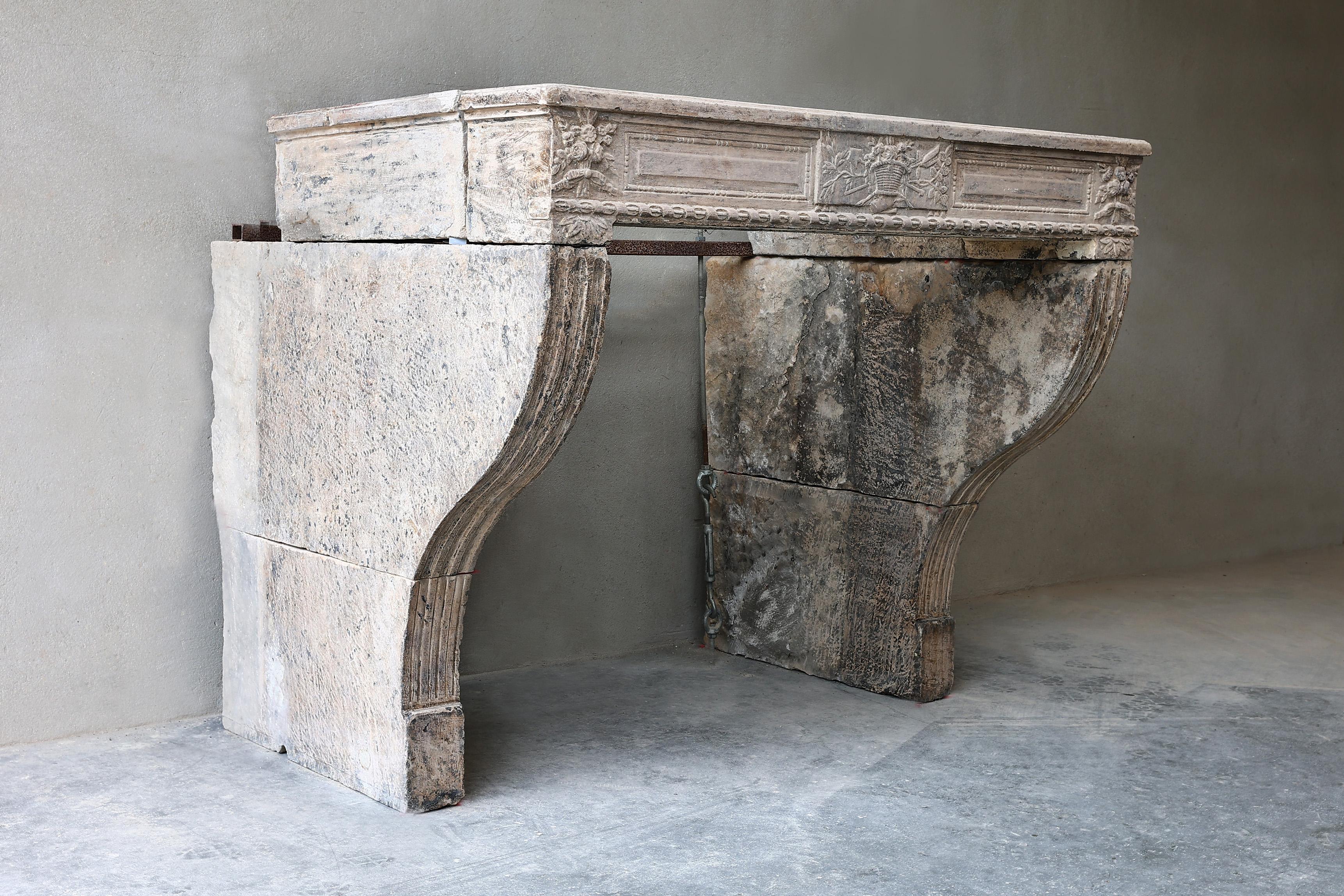 Beautiful decorative and antique fireplace from the 19th century in the style of Louis XVI. This French limestone mantel has beautiful ornaments and beautiful lines and fluting on the legs! The dimensions of this fireplace make it suitable for many